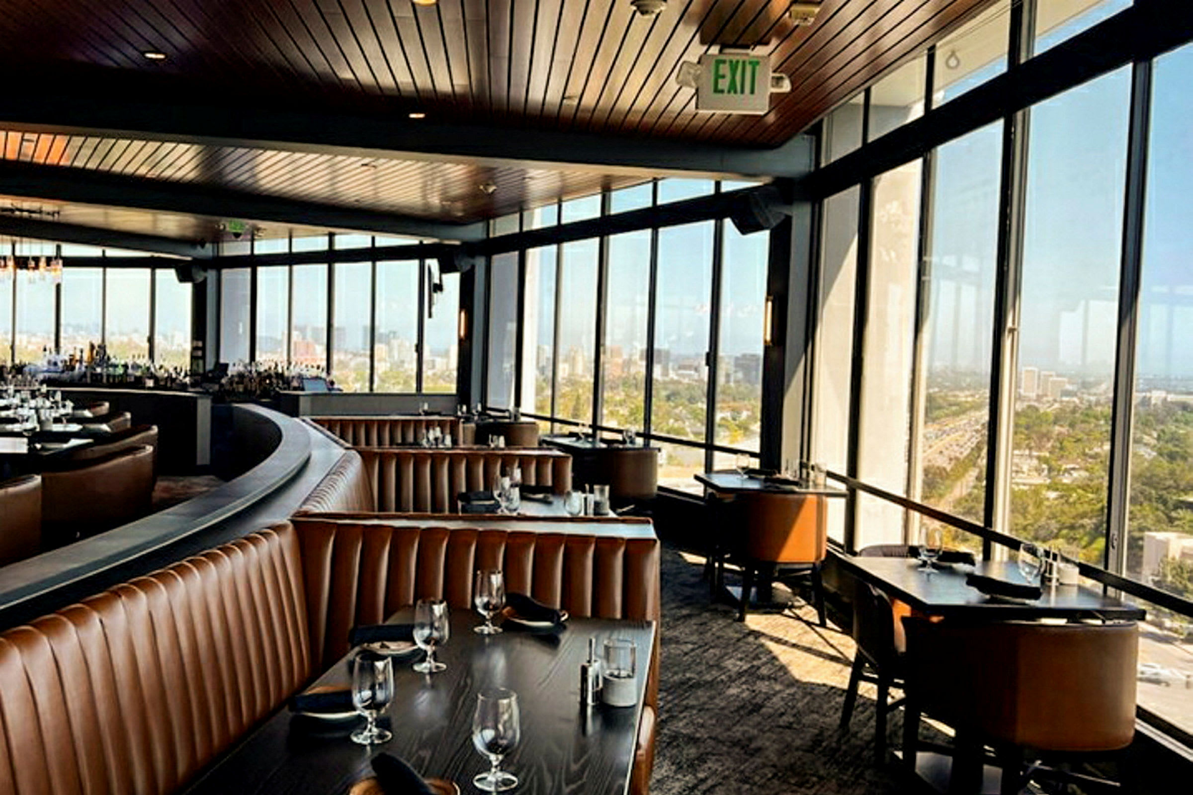 Interiør i en rummelig restaurant med panoramaudsigt gennem store vinduer. (AI-genereret tekst)
