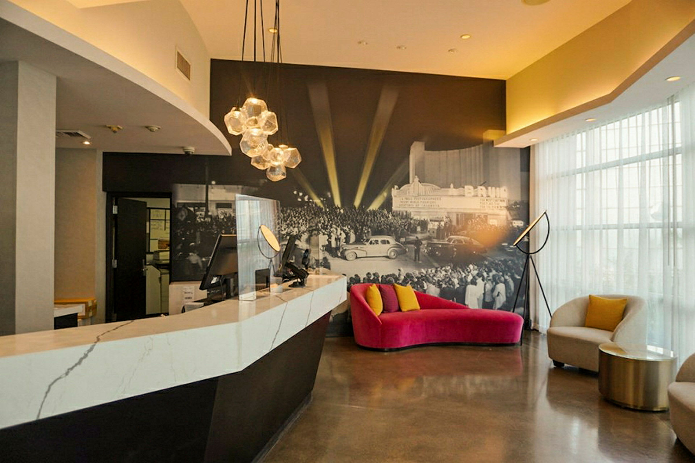 Reception og siddeområder med moderne indretning og en vægmaleri af en begivenhed. (AI-genereret tekst)