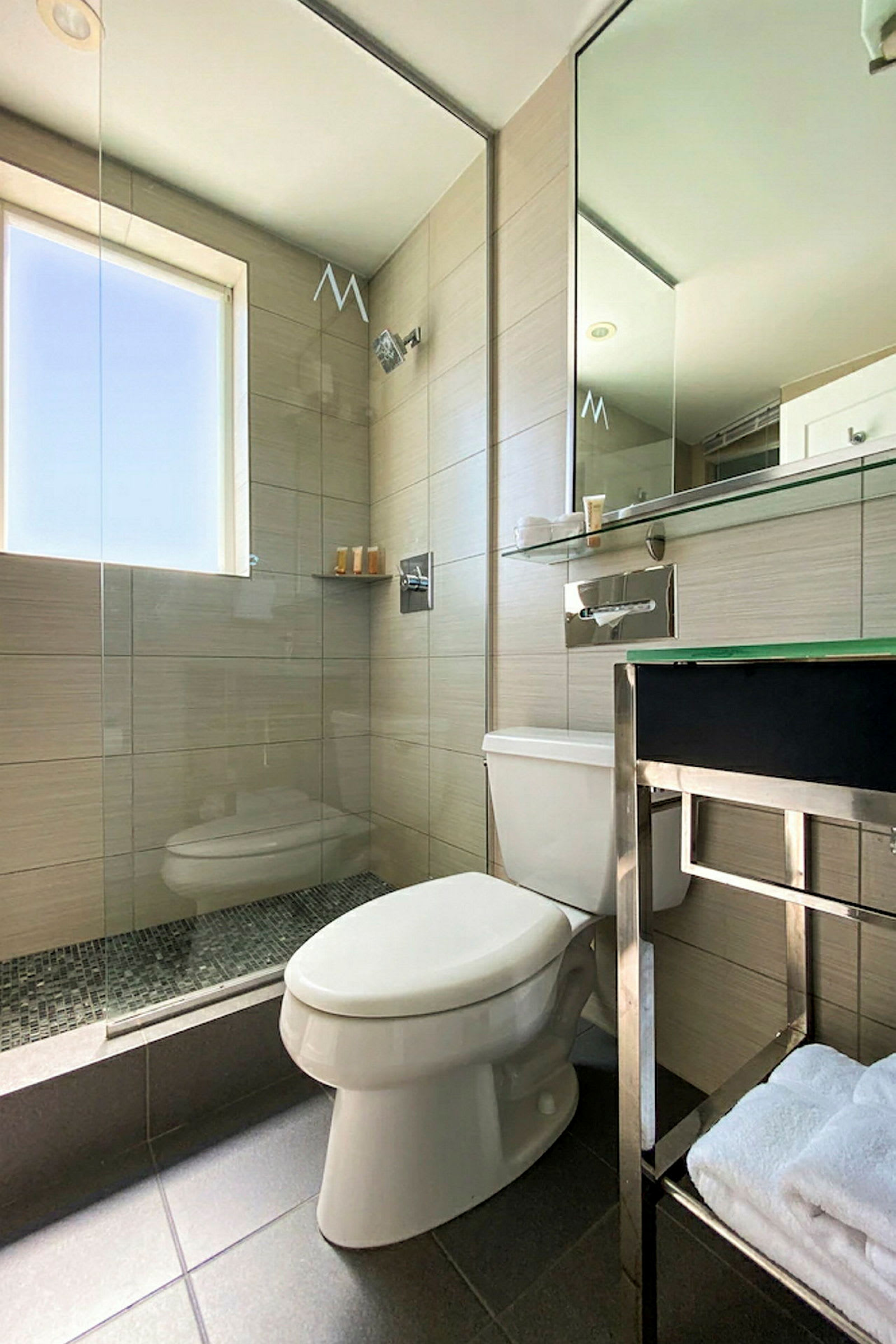 Et moderne badeværelse med brusekabine, toilet og spejl. (AI-genereret tekst)