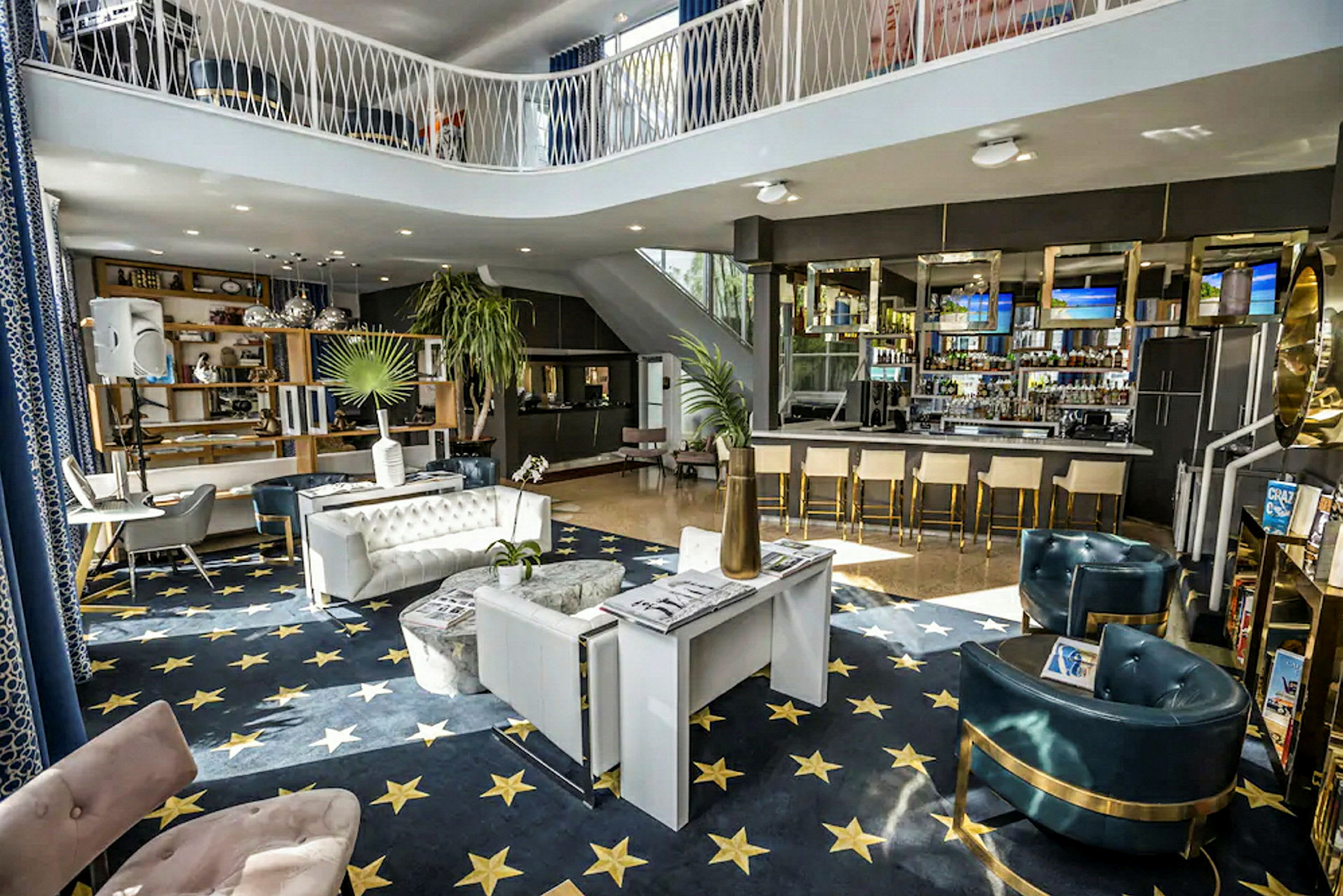 Billede af et indendørsmiljø med moderne møbler, et stort blåt gulv med stjerner og en elegant indrettet bar. (AI-genereret tekst)