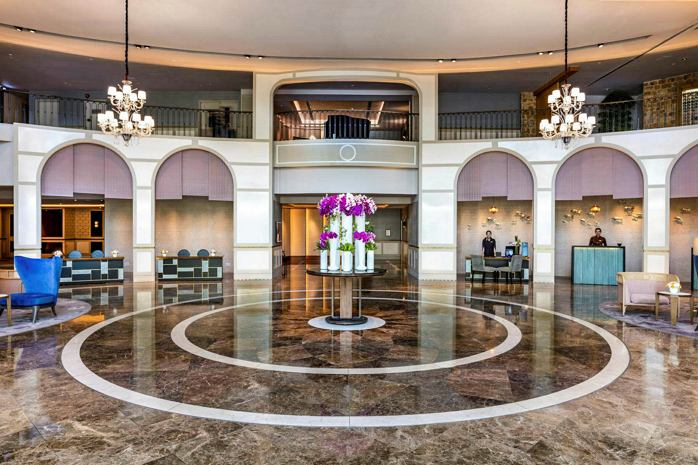 Hotellets foyer med marmorgulv, reception og skulptur med blomster. (AI-genereret tekst)