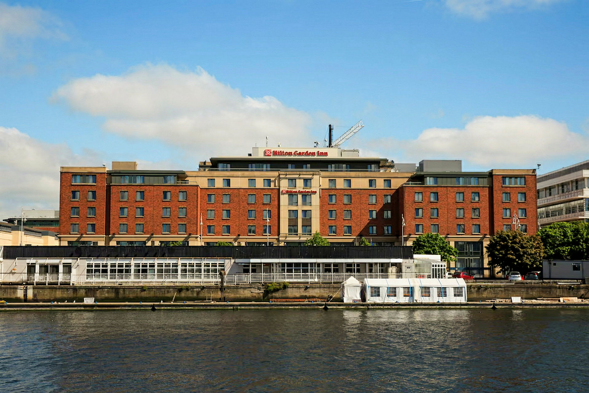 En bygning mærket som Hilton Garden Inn ved en vandsamling. (AI-genereret tekst)