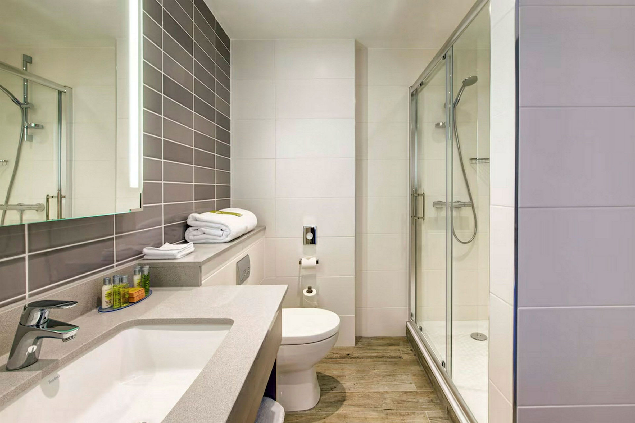 Et moderne badeværelse med brusekabine, toilet og håndvask. (AI-genereret tekst)