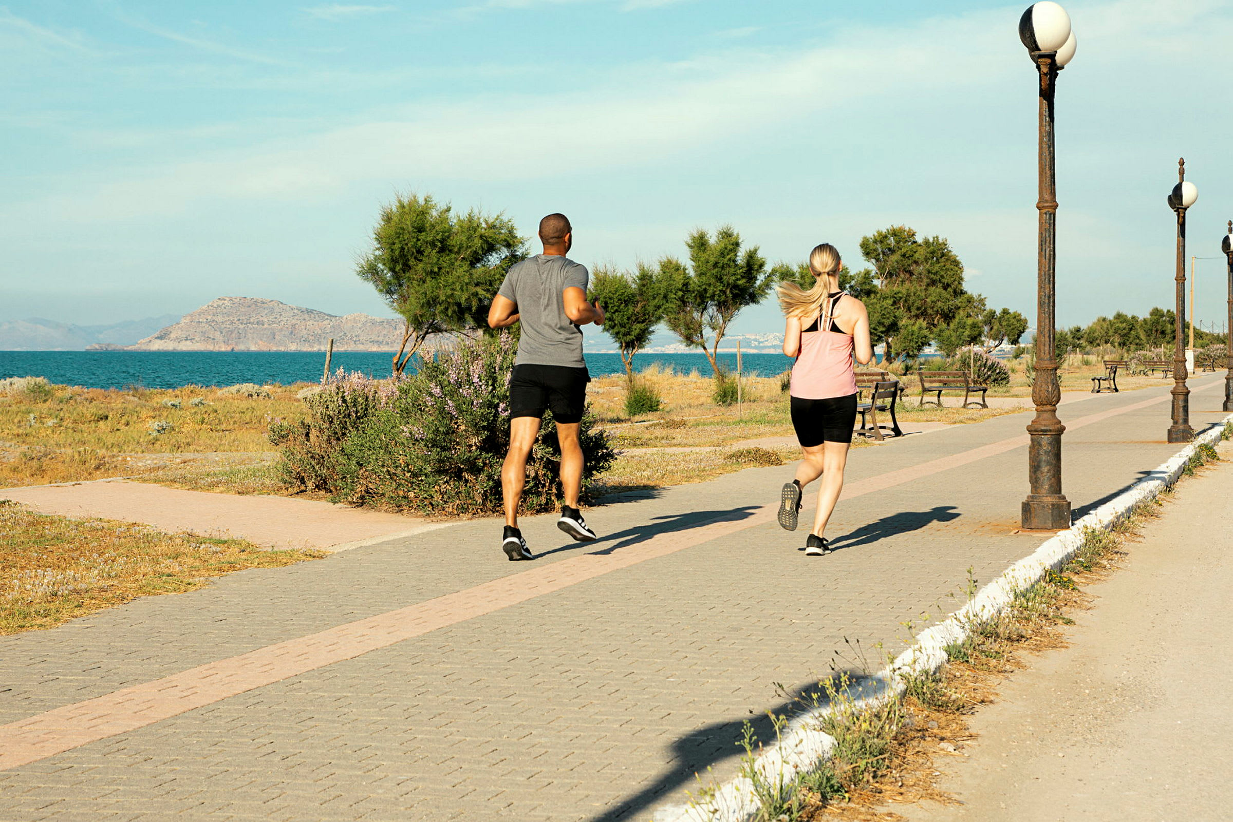 To personer jogger på en gangsti ved havet. (AI-genereret tekst)