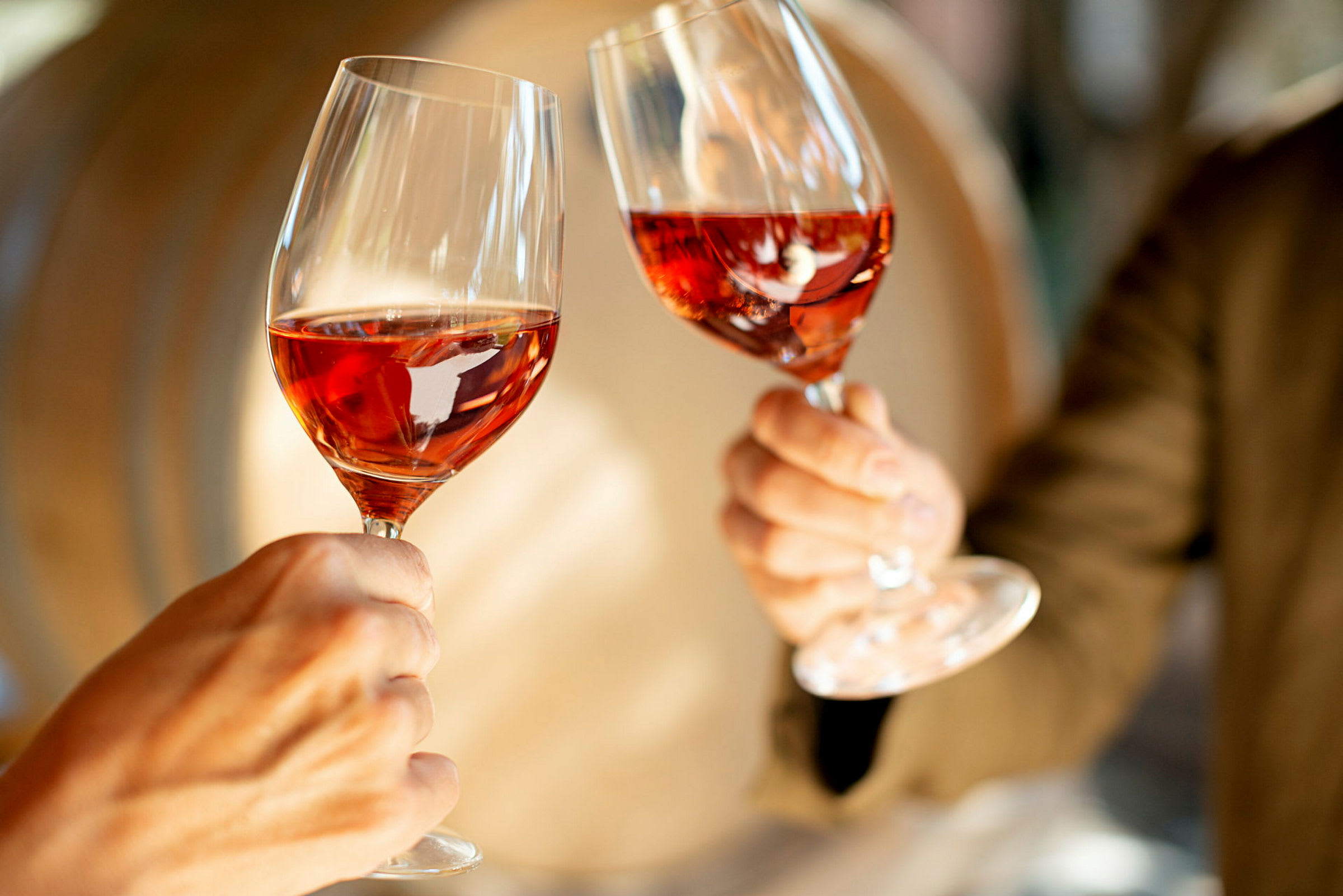 To glas med rosévin løftes op. (AI-genereret tekst)