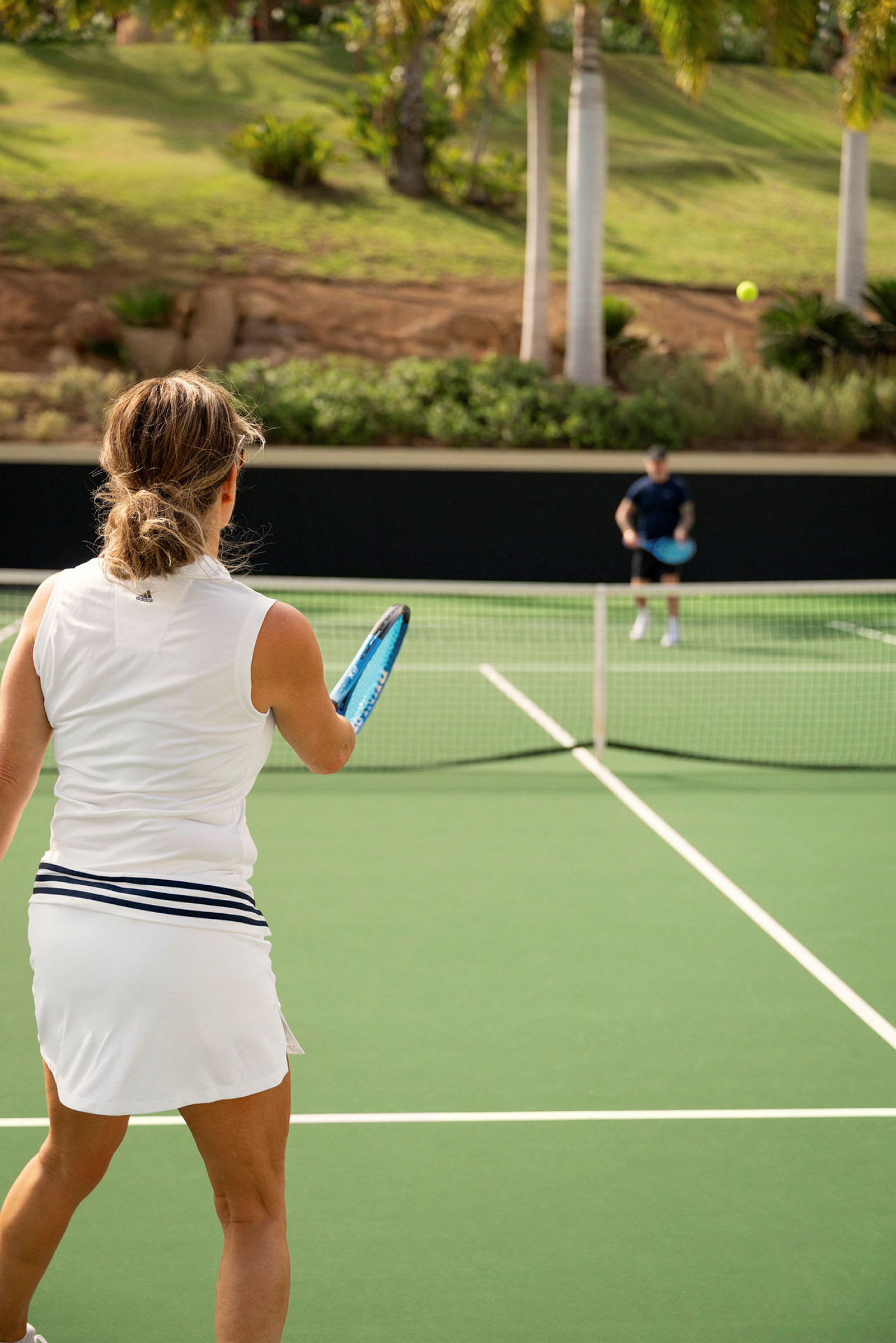 En kvinde spiller tennis på en udendørs bane. (AI-genereret tekst)