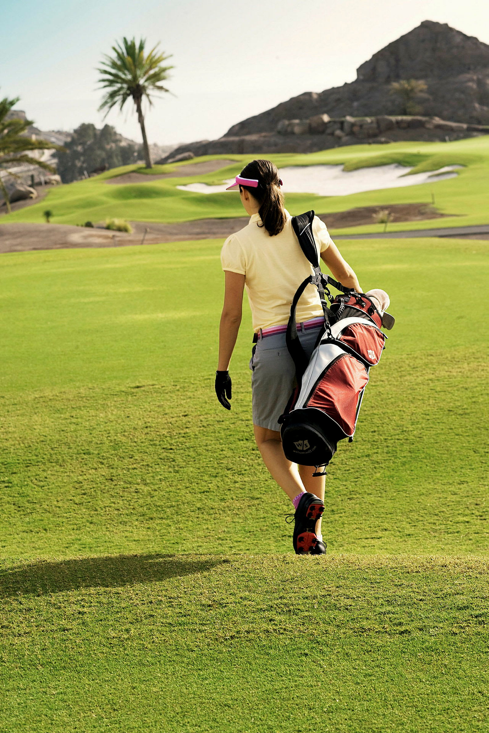 En person går på en golfbane med en golfbag på skulderen. (AI-genereret tekst)