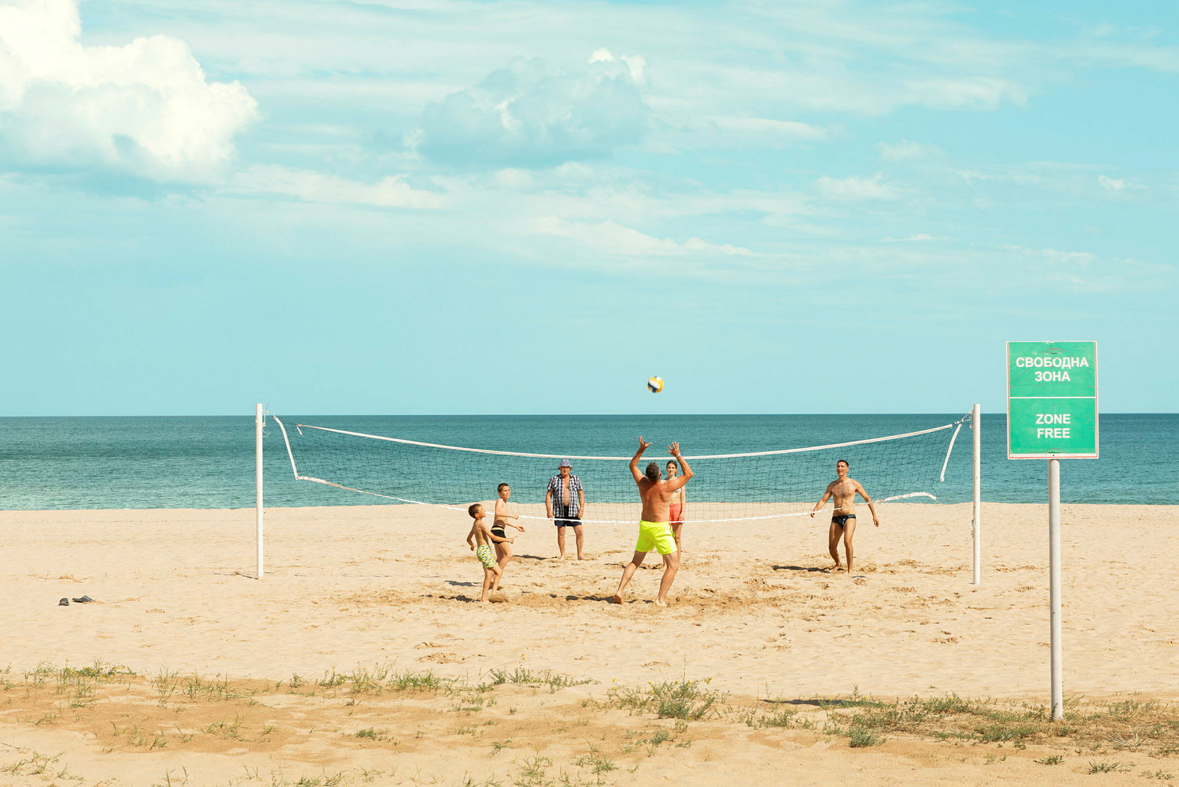 Mennesker spiller strandvolleyball ved stranden. (AI-genereret tekst)