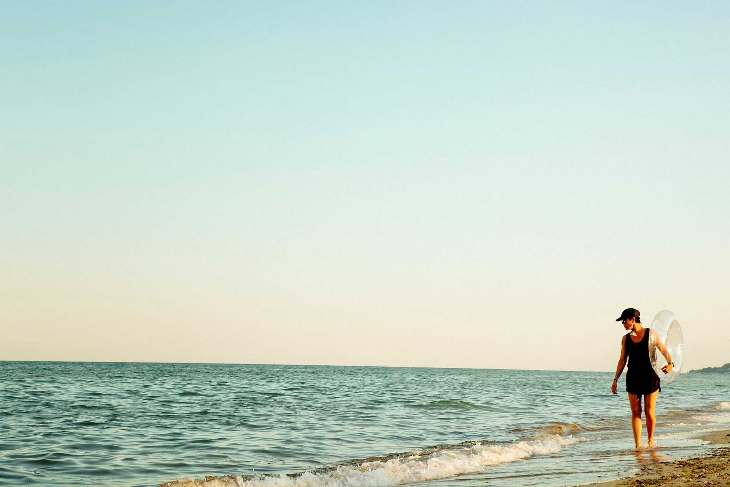 Person går langs strandkanten ved havet. (AI-genereret tekst)