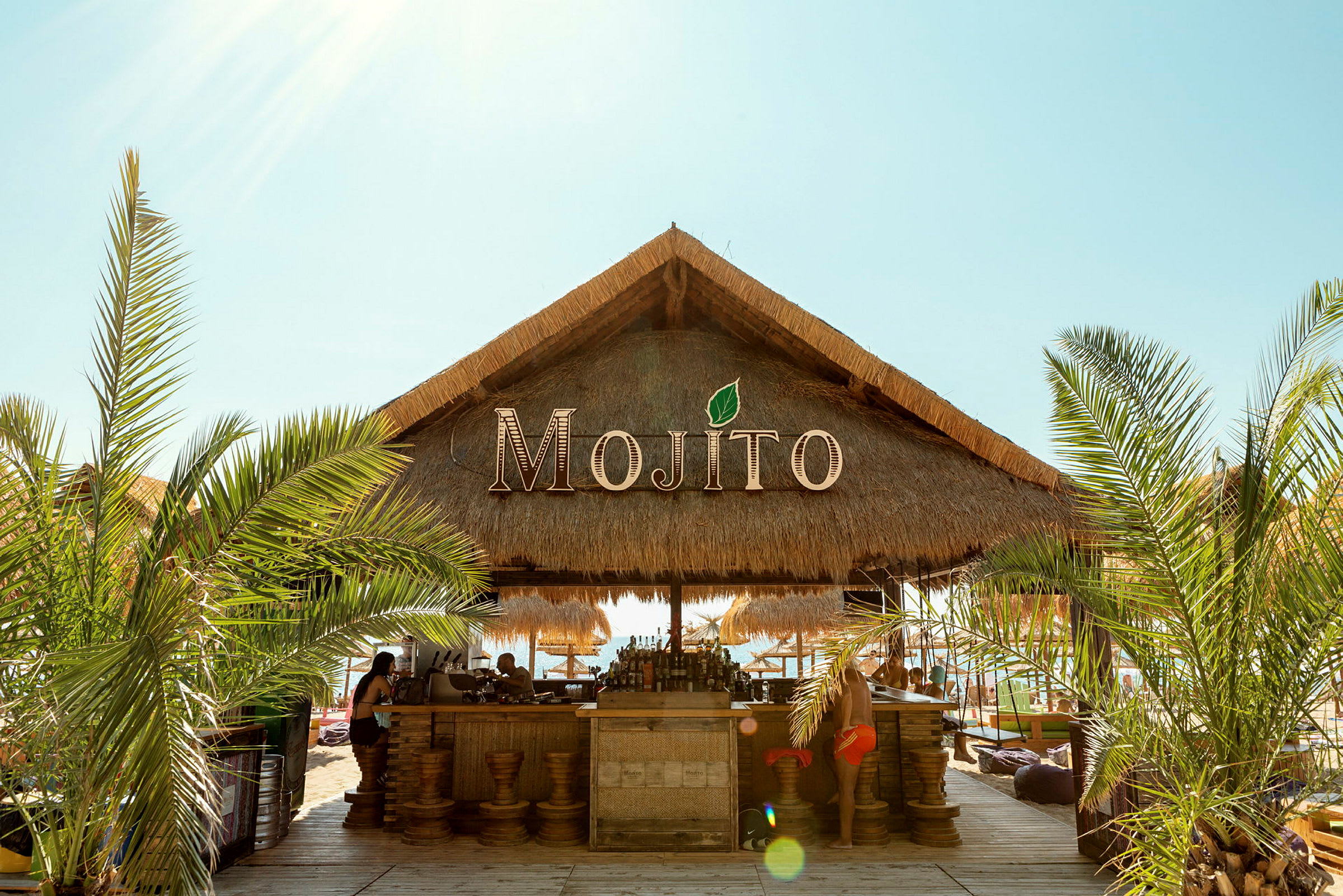 En strandbar med stråtag og navnet Mojito. (AI-genereret tekst)