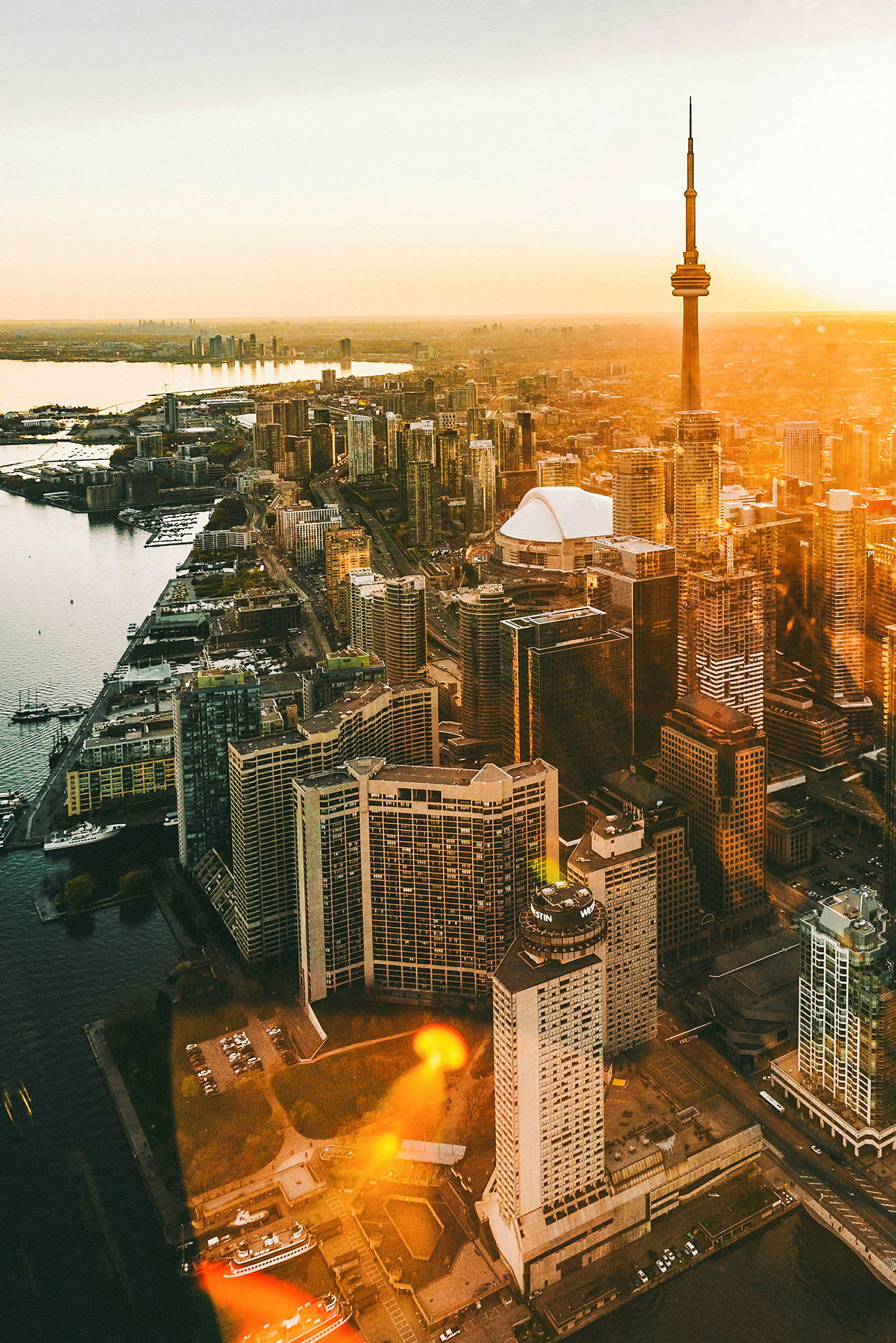 Billede med udsigt over Toronto med CN Tower ved solnedgang. (AI-genereret tekst)