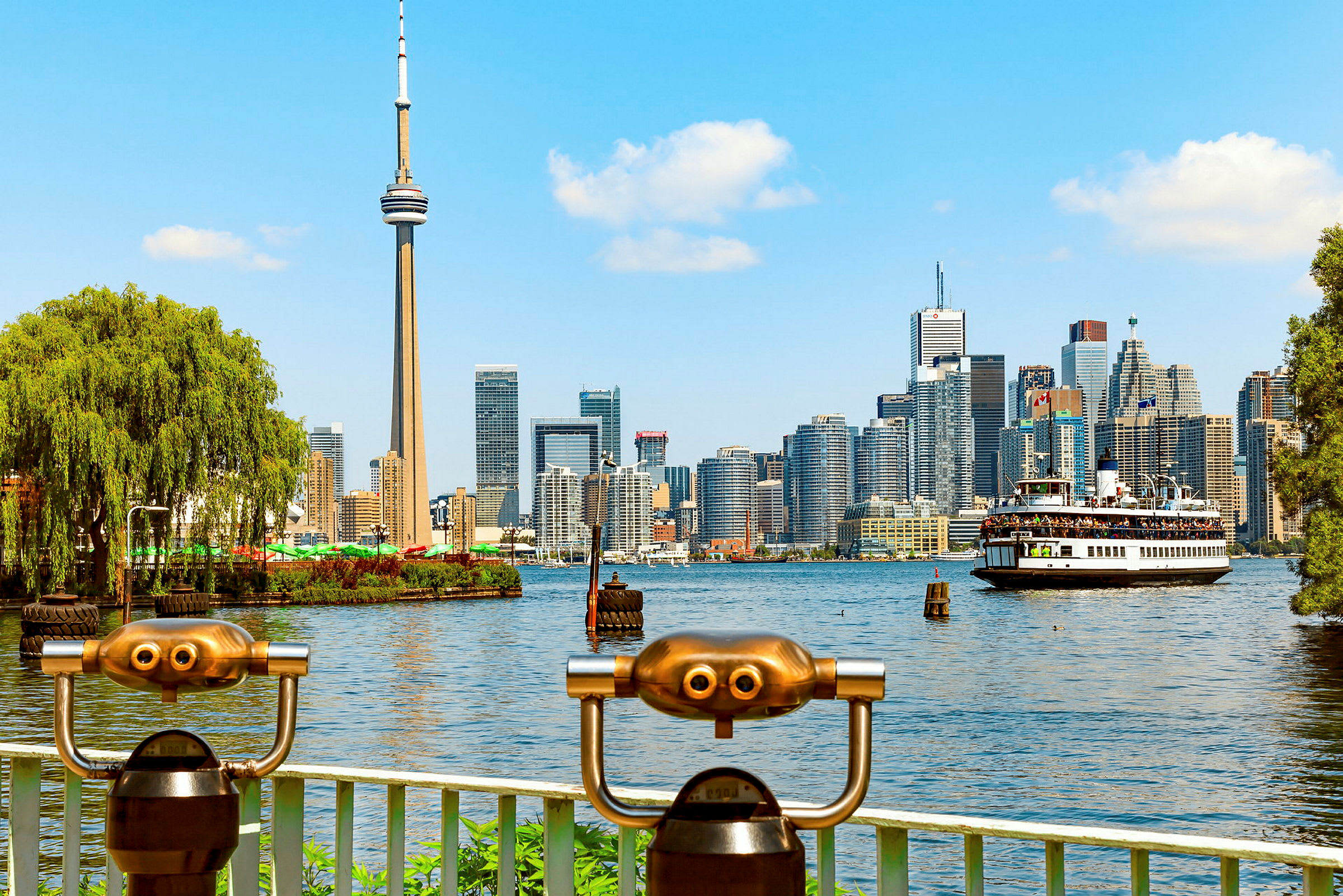 Udsigt over Torontos skyline med CN Tower og en færge på vandet. (AI-genereret tekst)