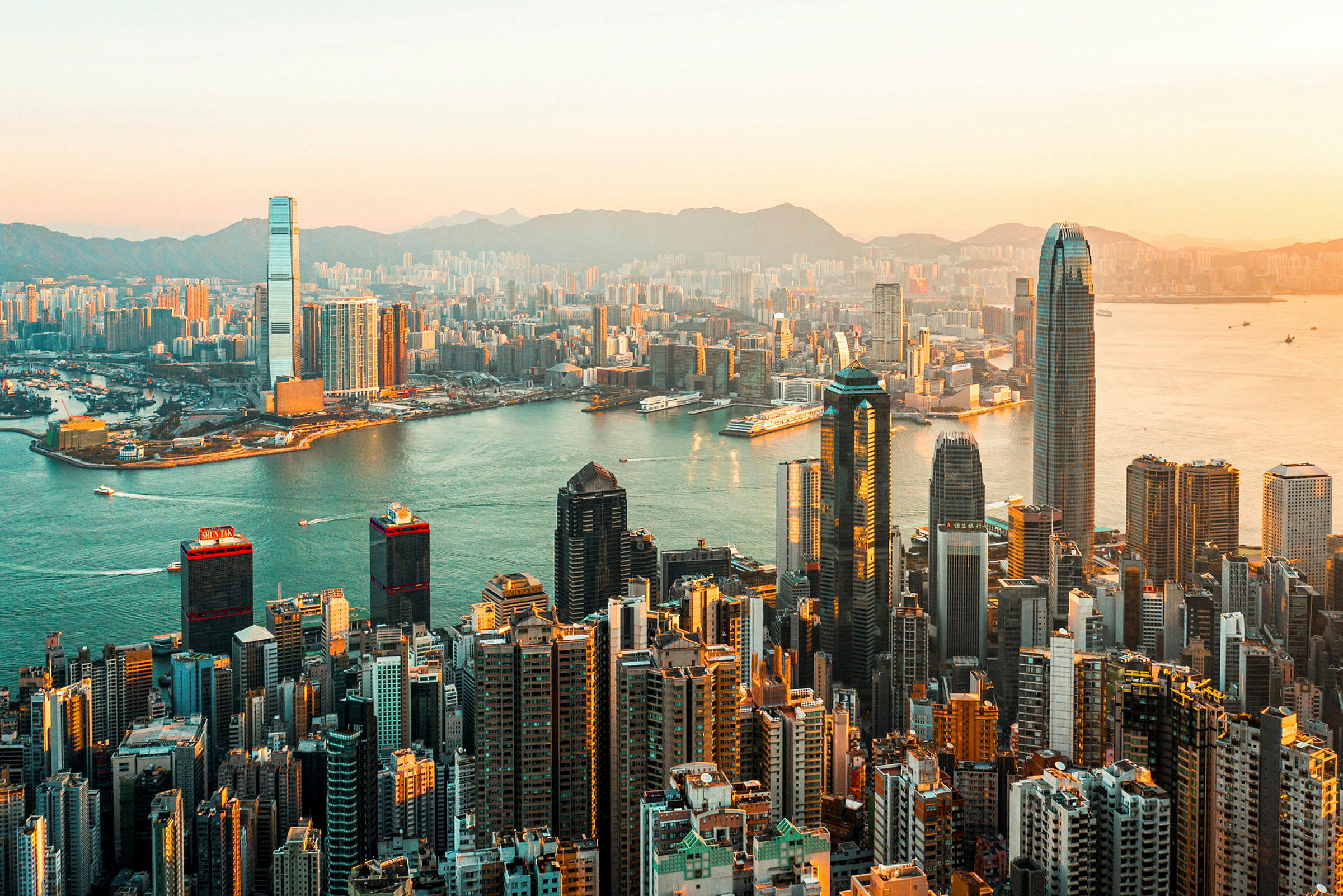 Udsigt over Hong Kong og dens skyskrabere ved solnedgang. (AI-genereret tekst)