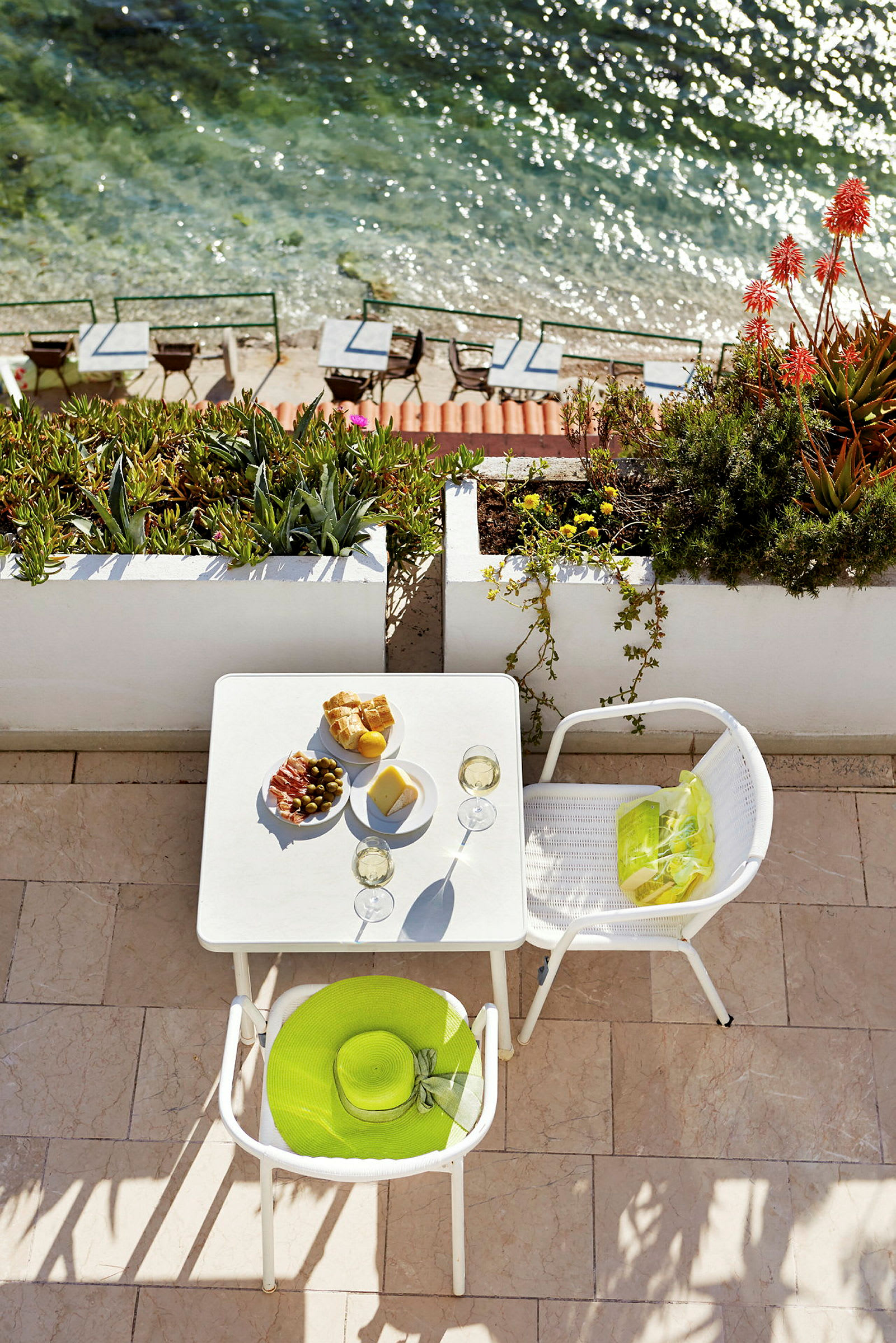 Bord med mad og drikke på terrasse ved havet. (AI-genereret tekst)