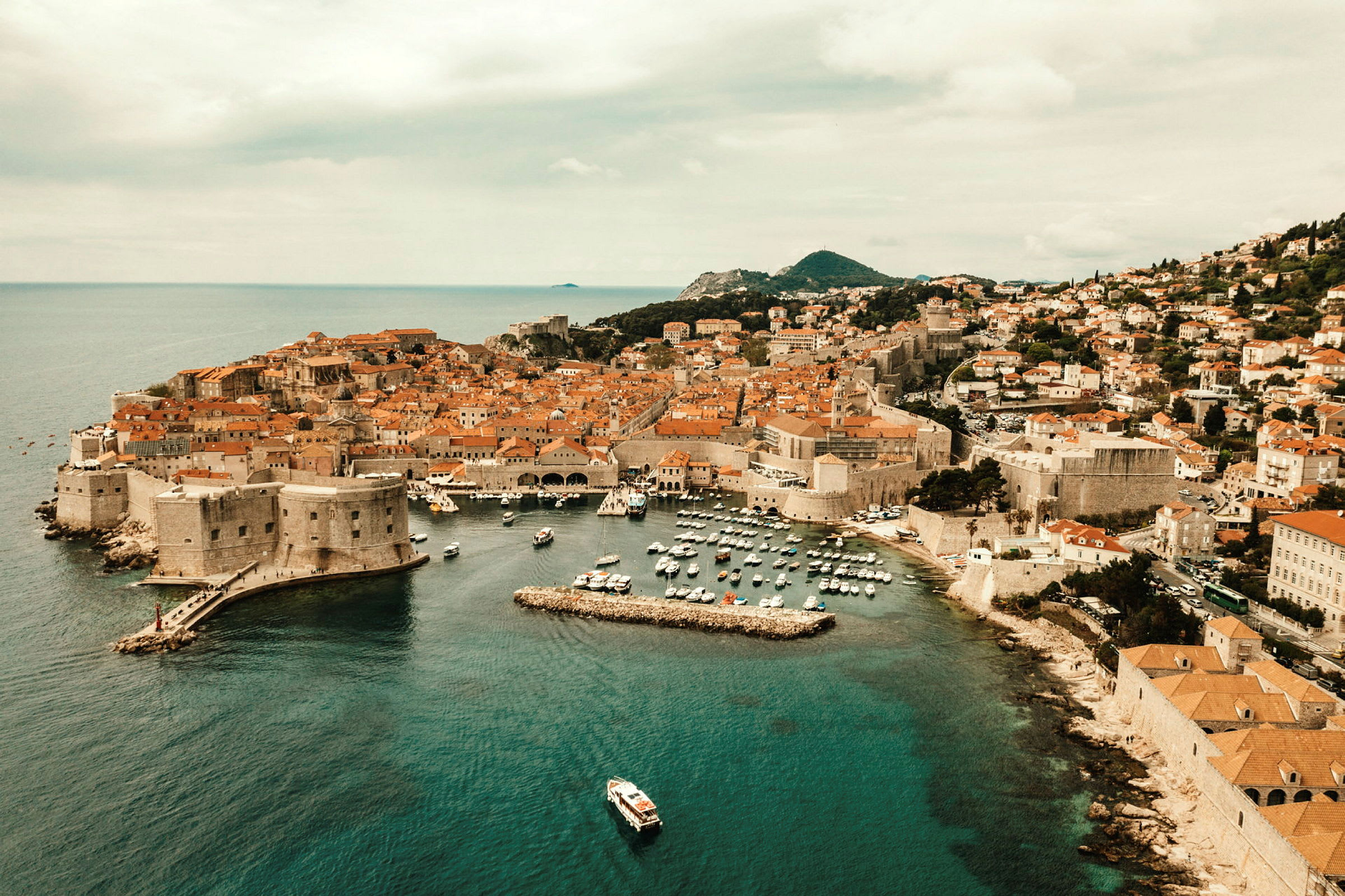 Udsigt over Dubrovnik med den gamle bys mure og havnen. (AI-genereret tekst)