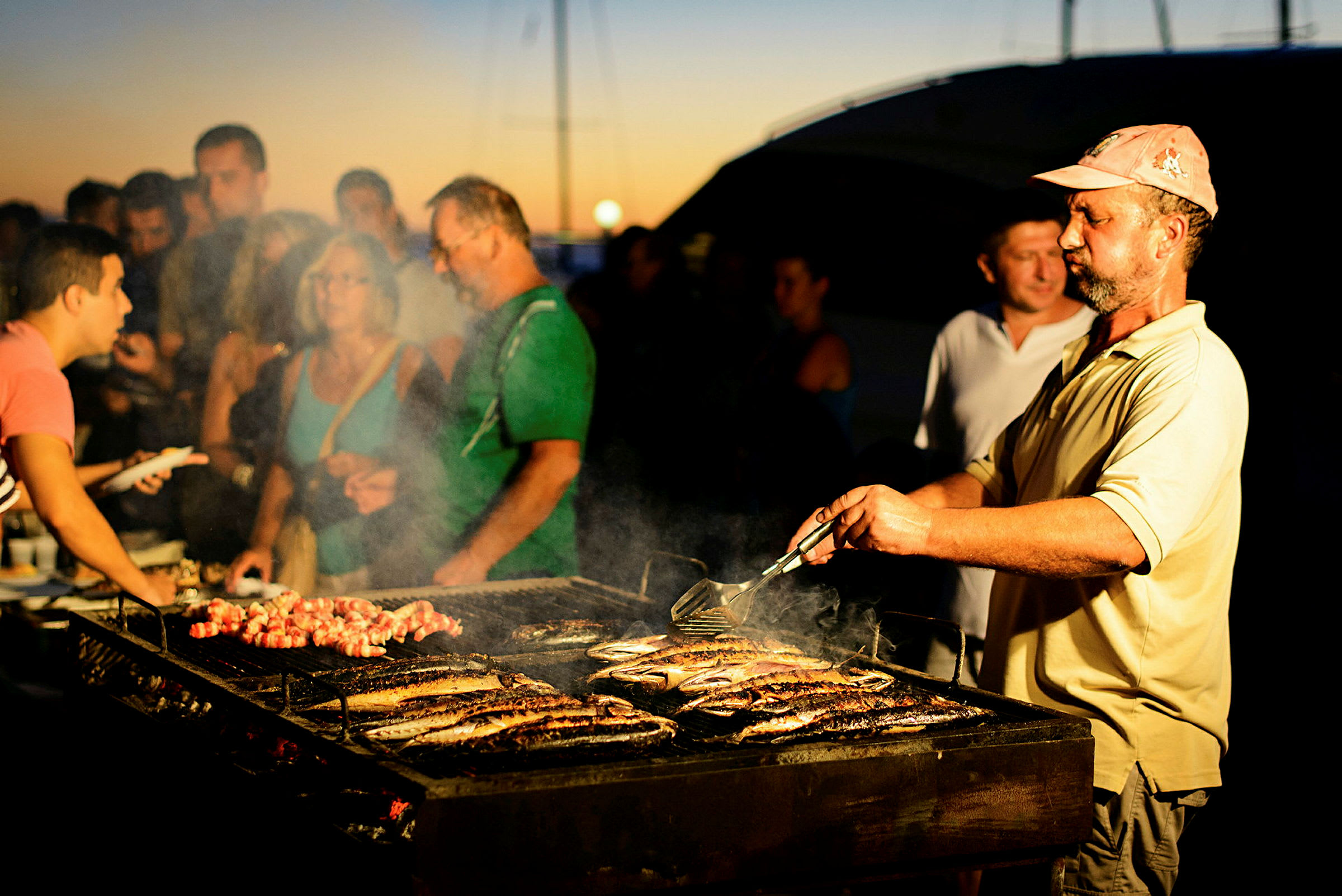 Person tilbereder mad på en grill udendørs. (AI-genereret tekst)