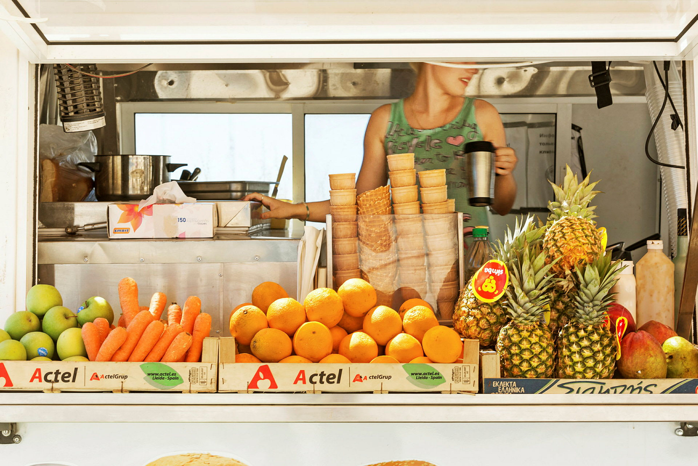 En markedsbod med frugt, inklusive gulerødder, appelsiner og ananas. (AI-genereret tekst)
