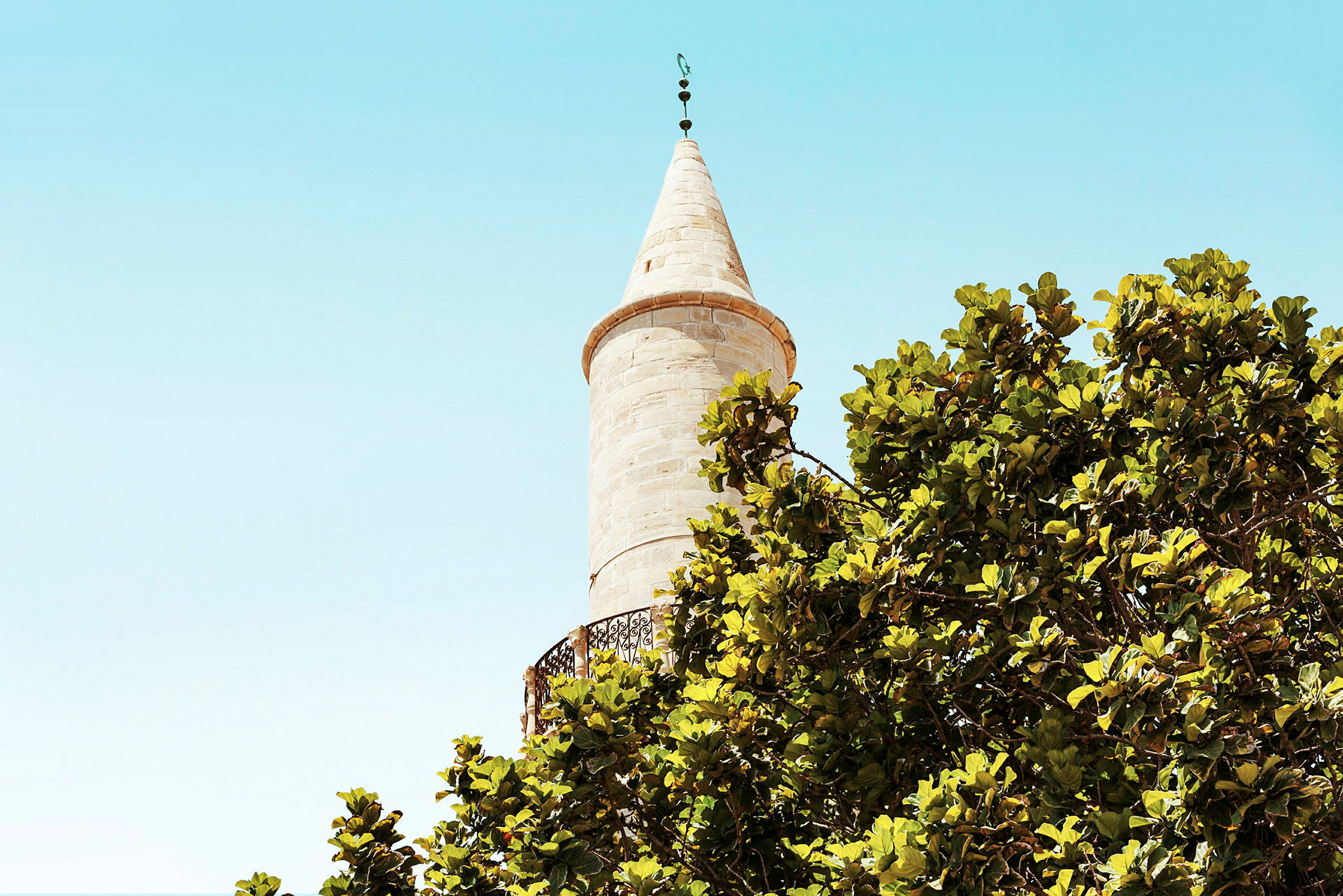 En minaret med træer i forgrunden. (AI-genereret tekst)