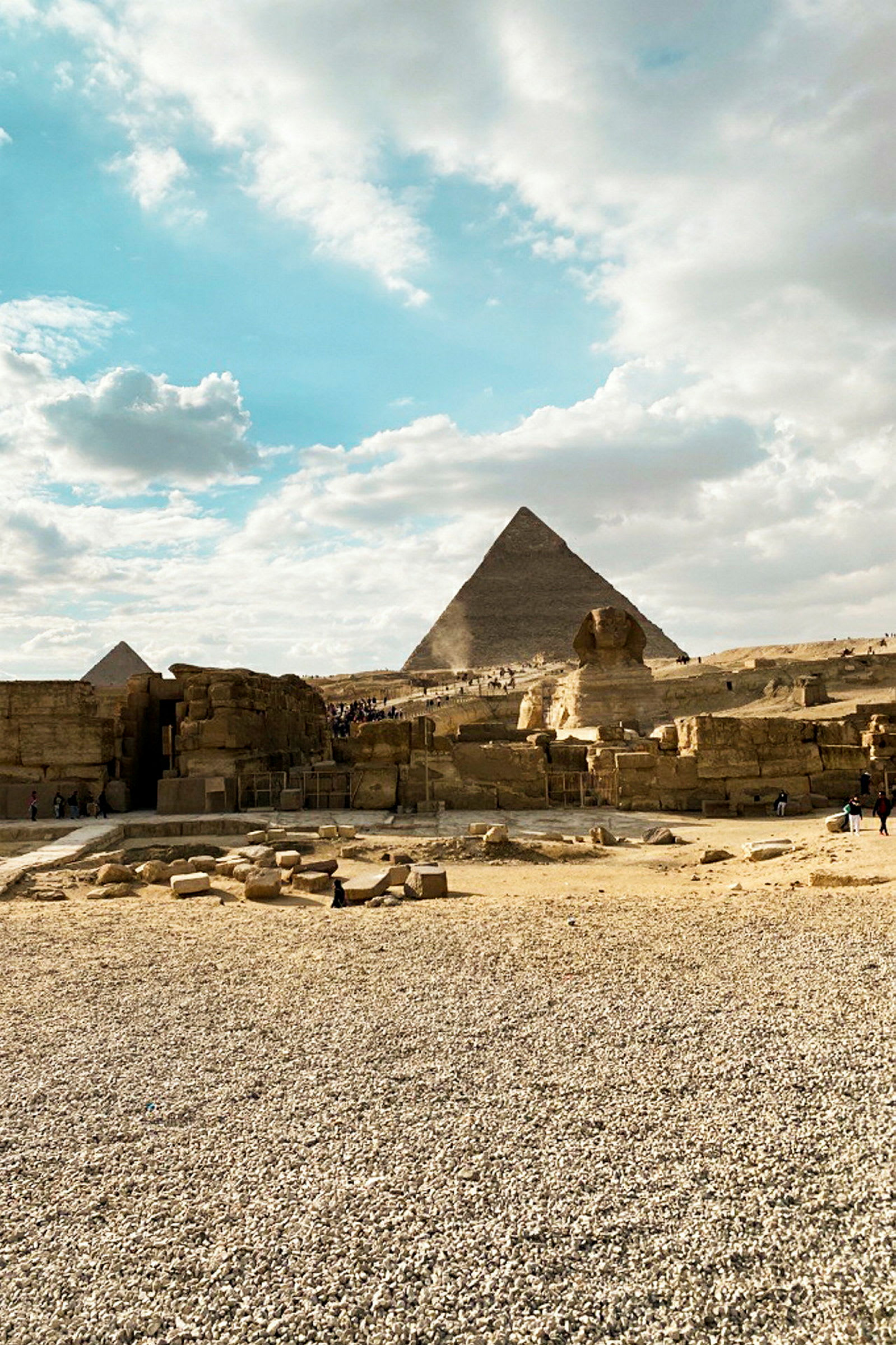 Stenet område med pyramider og sfinks under en klar himmel. (AI-genereret tekst)