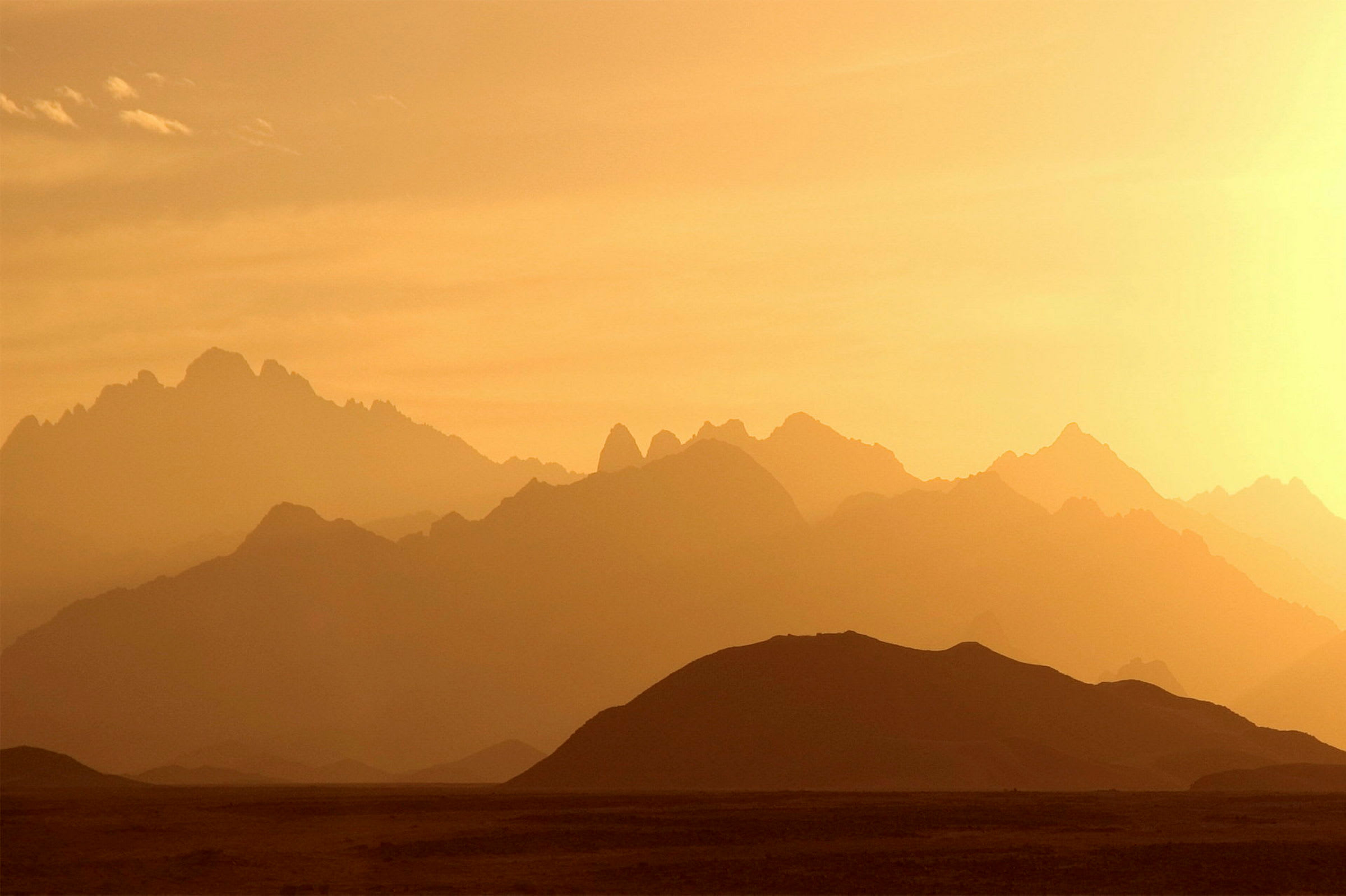 Bjerglandskab i solnedgang med skarpe silhouetter. (AI-genereret tekst)