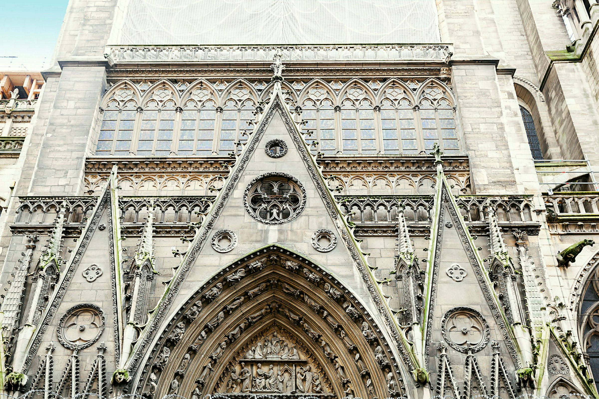 Detaljeret facade af en gotisk kirkebygning med ornamenterede buer og vinduer. (AI-genereret tekst)
