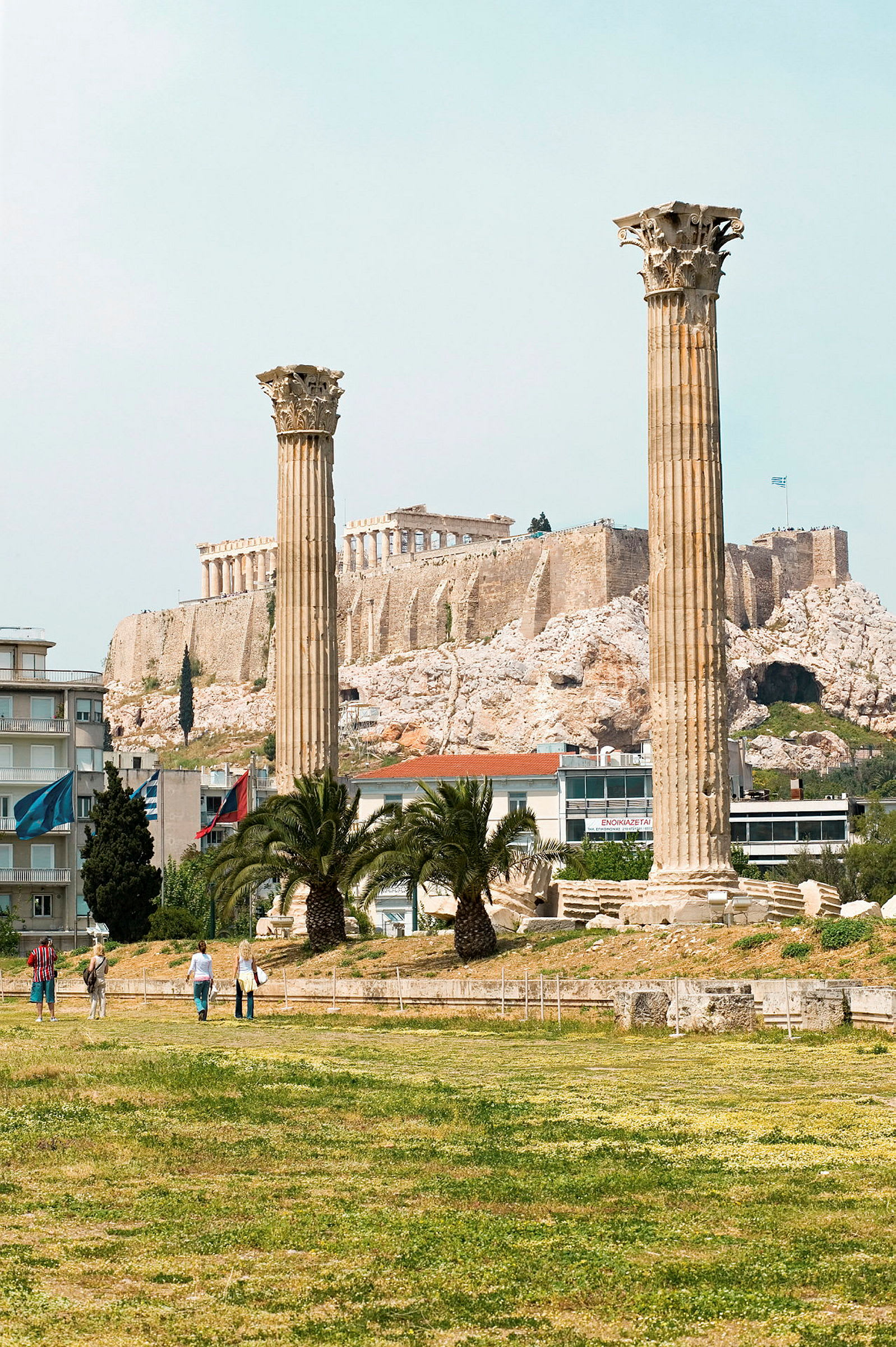 To antikke søjler i forgrunden med Akropolis i baggrunden. (AI-genereret tekst)