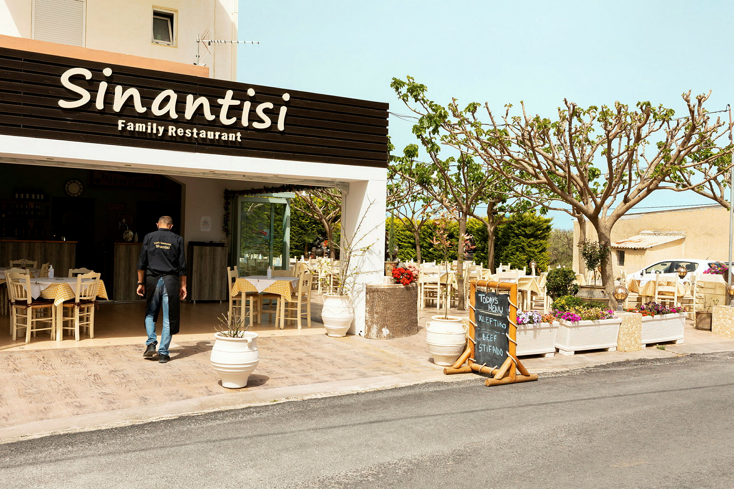 Restauranten Sinantisi med udendørs servering dekoreret med blomster. (AI-genereret tekst)