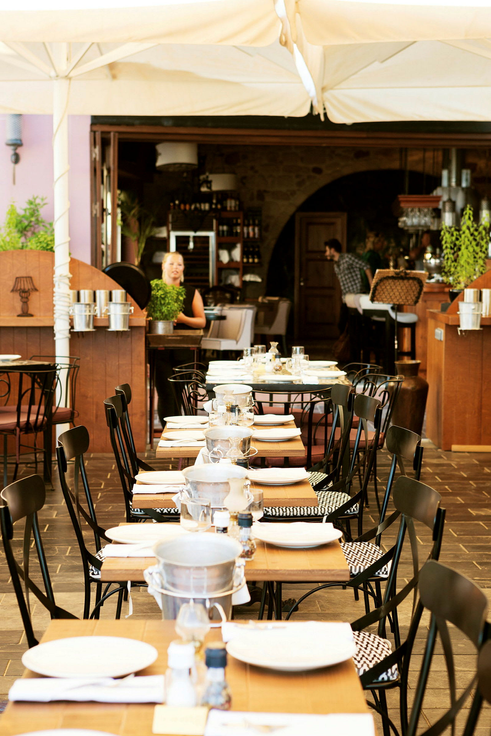 En restaurant med dækkede borde udendørs under et telt. (AI-genereret tekst)