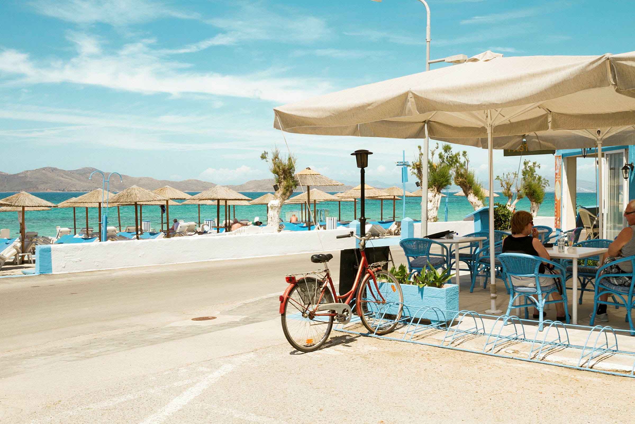Cykel parkeret ved en café med udsigt over stranden og havet. (AI-genereret tekst)