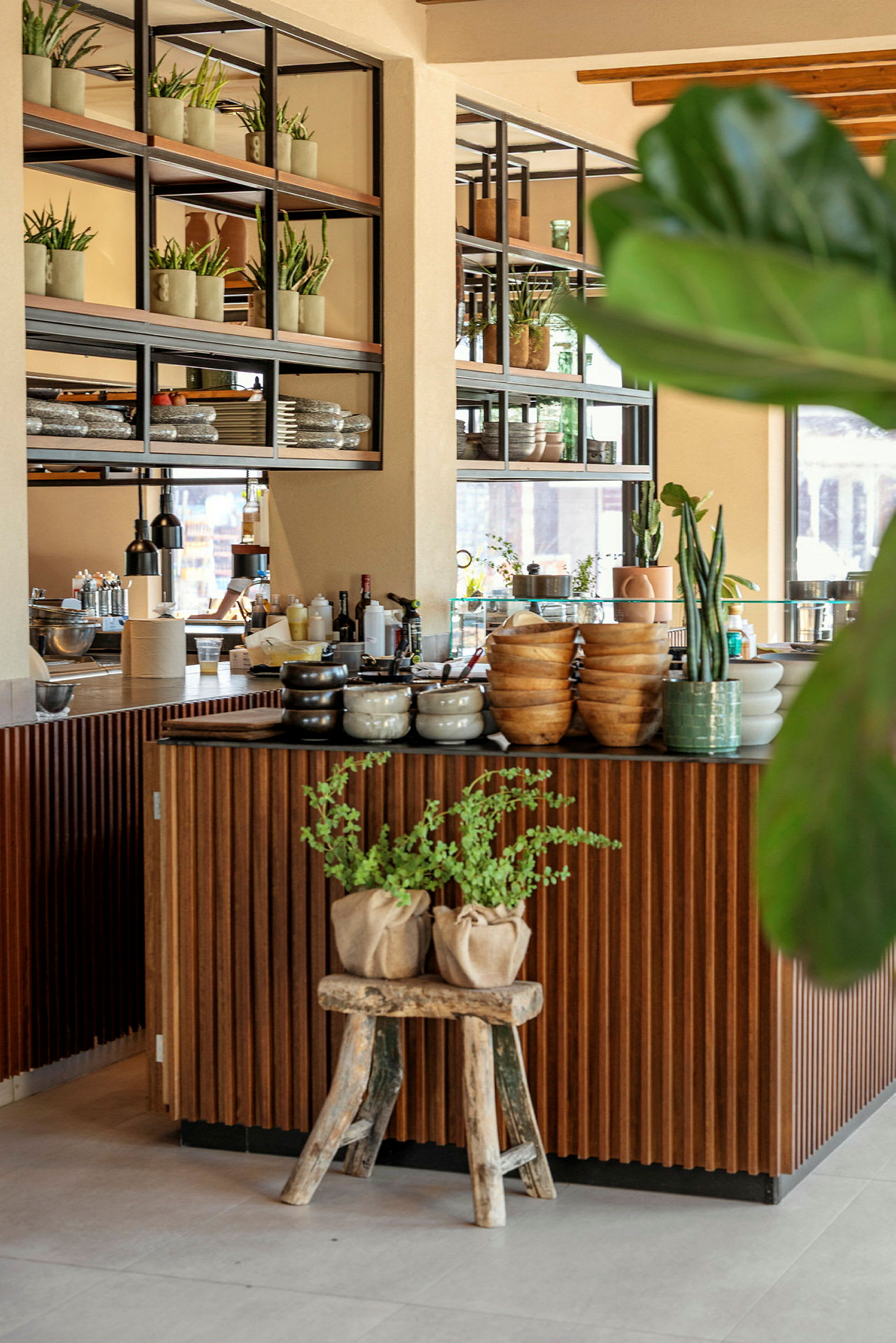 En moderne café med dekorative planter og trædetaljer. (AI-genereret tekst)