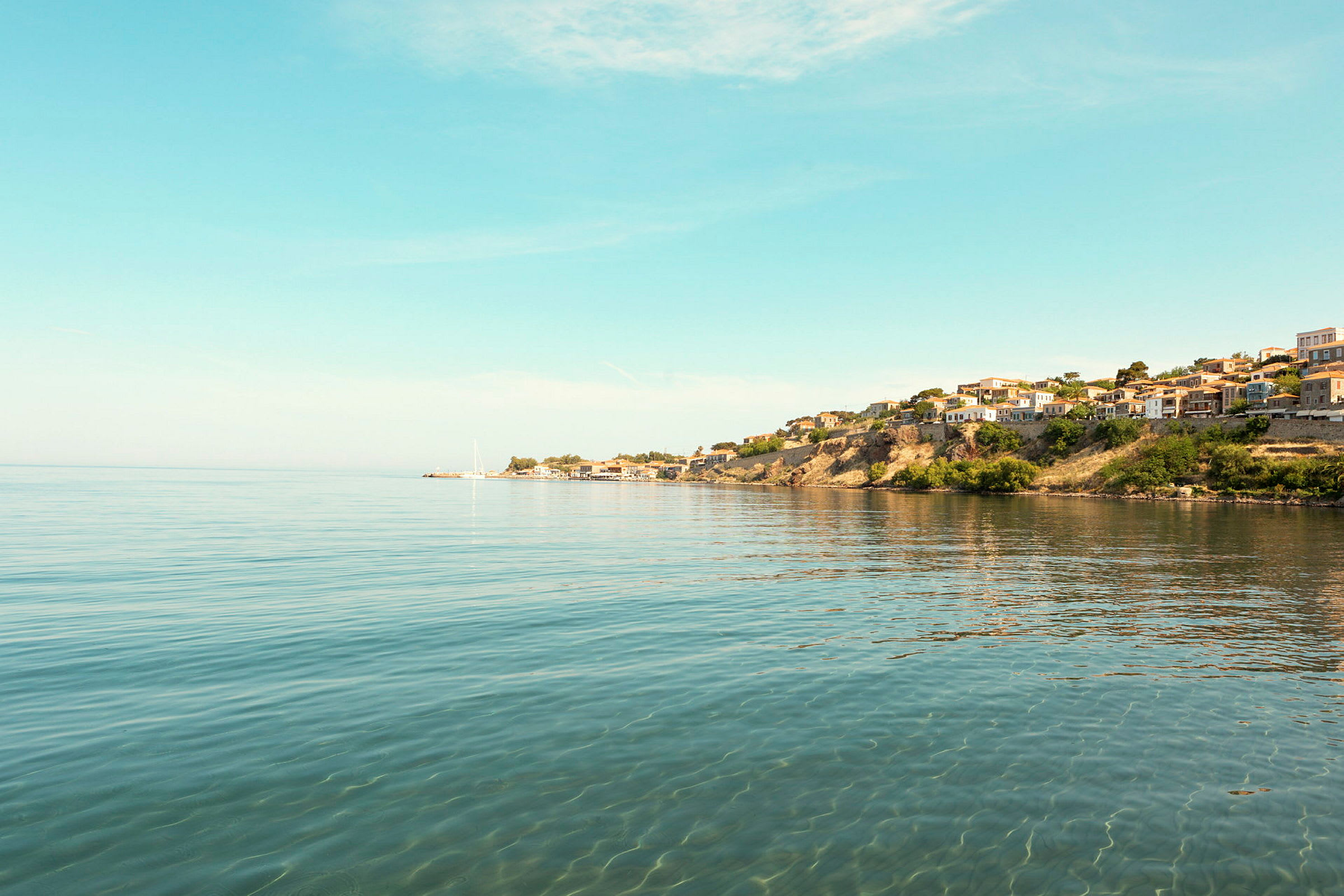 Udsigt over en kyst med huse på en klippe ved havet. (AI-genereret tekst)