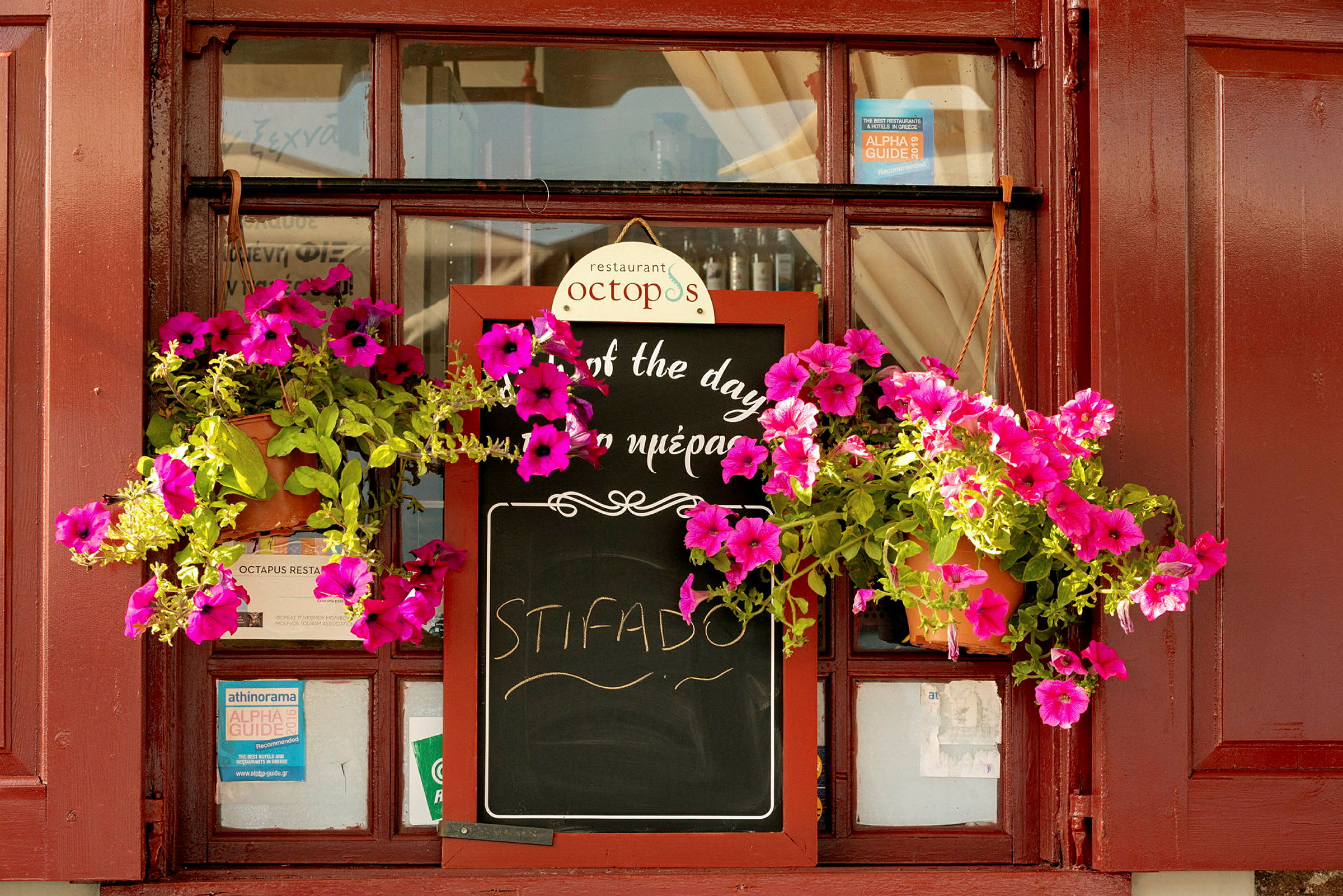 Et restaurantskilt med blomster, der hænger omkring det. (AI-genereret tekst)