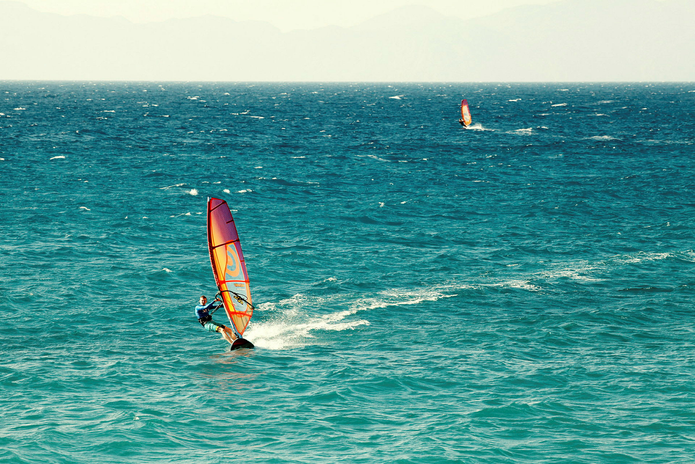 Person windsurfer på havet. (AI-genereret tekst)