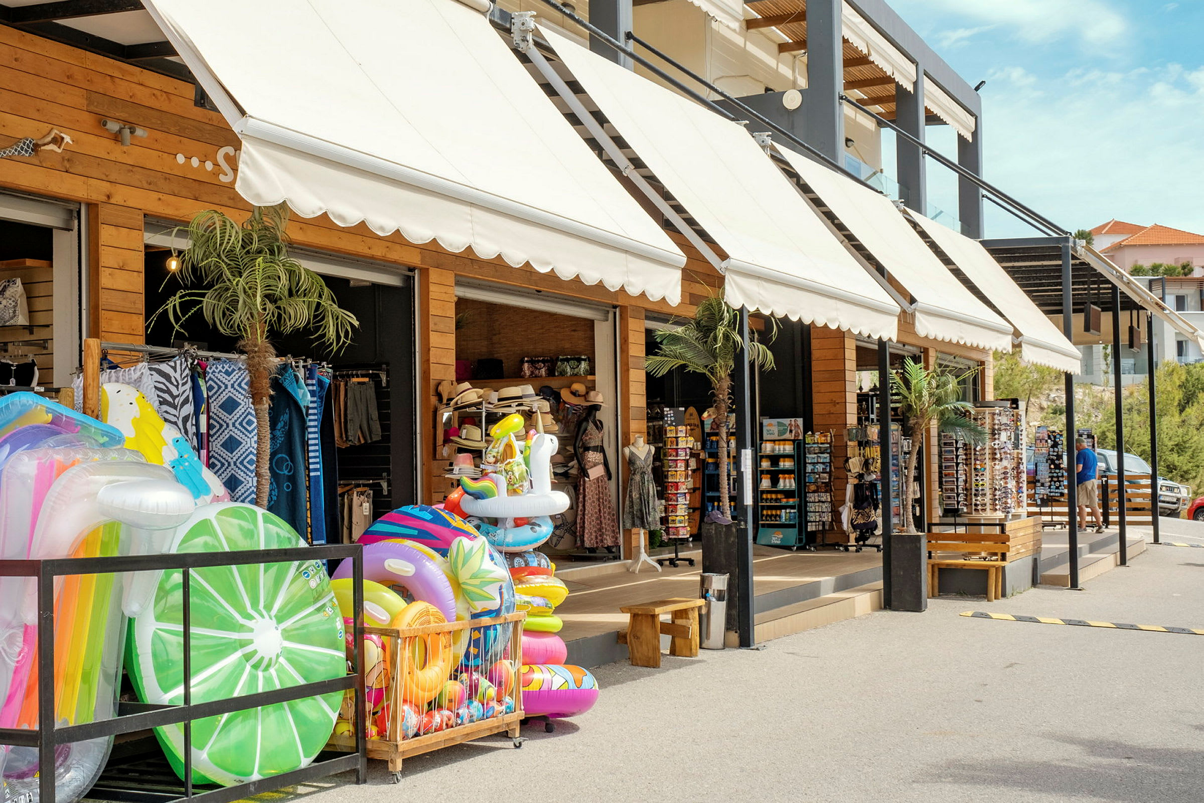 Butik med oppustelige badelegetøj og ferieartikler udstillet udenfor. (AI-genereret tekst)