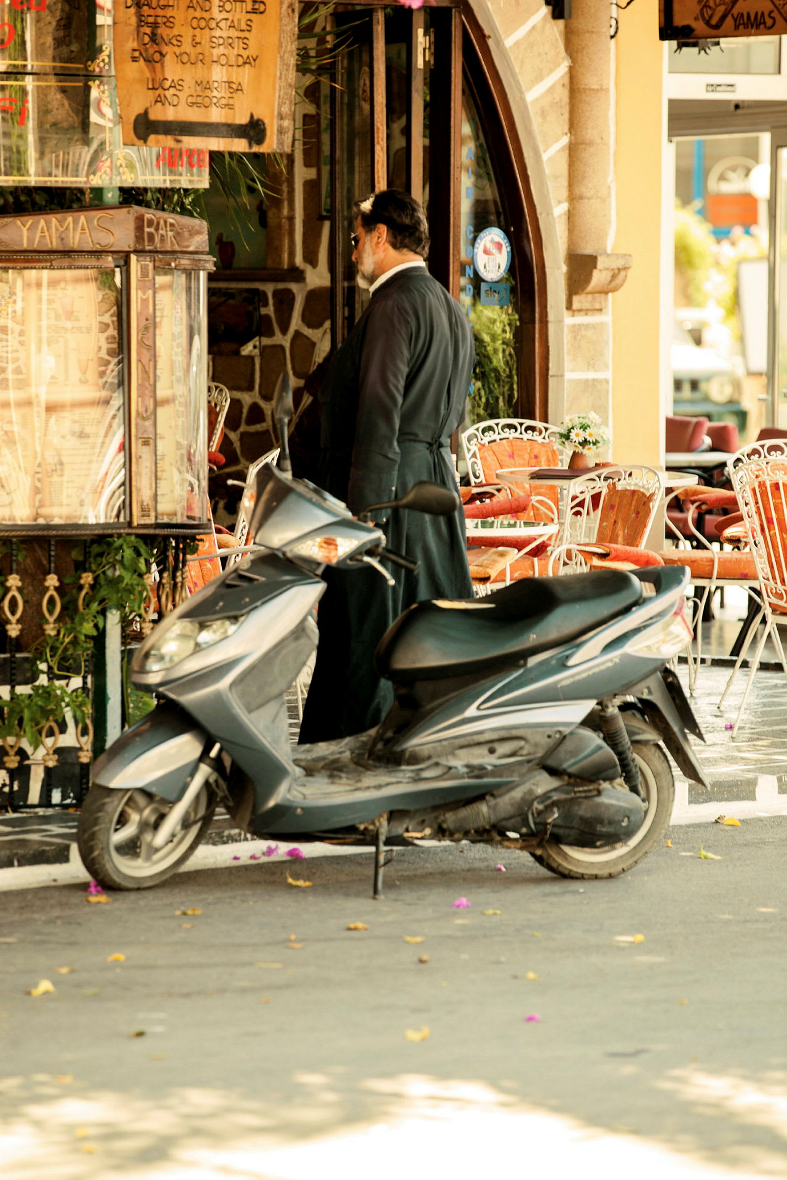 En motorcykel parkeret tæt på en restaurant med udendørs servering. (AI-genereret tekst)