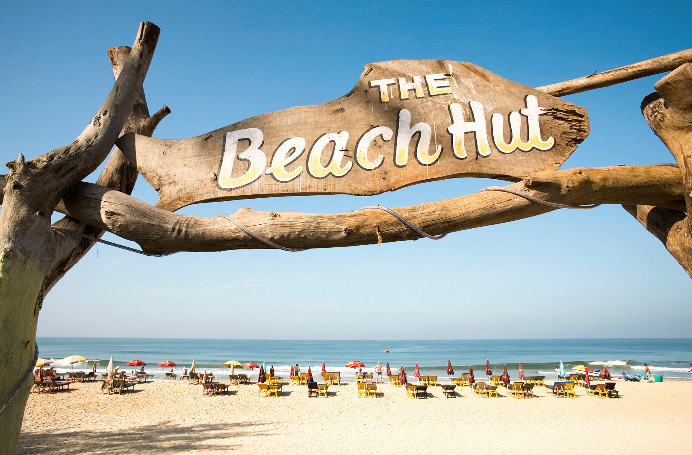 Et billede af en strand med et skilt med teksten "The Beach Hut" i forgrunden. (AI-genereret tekst)
