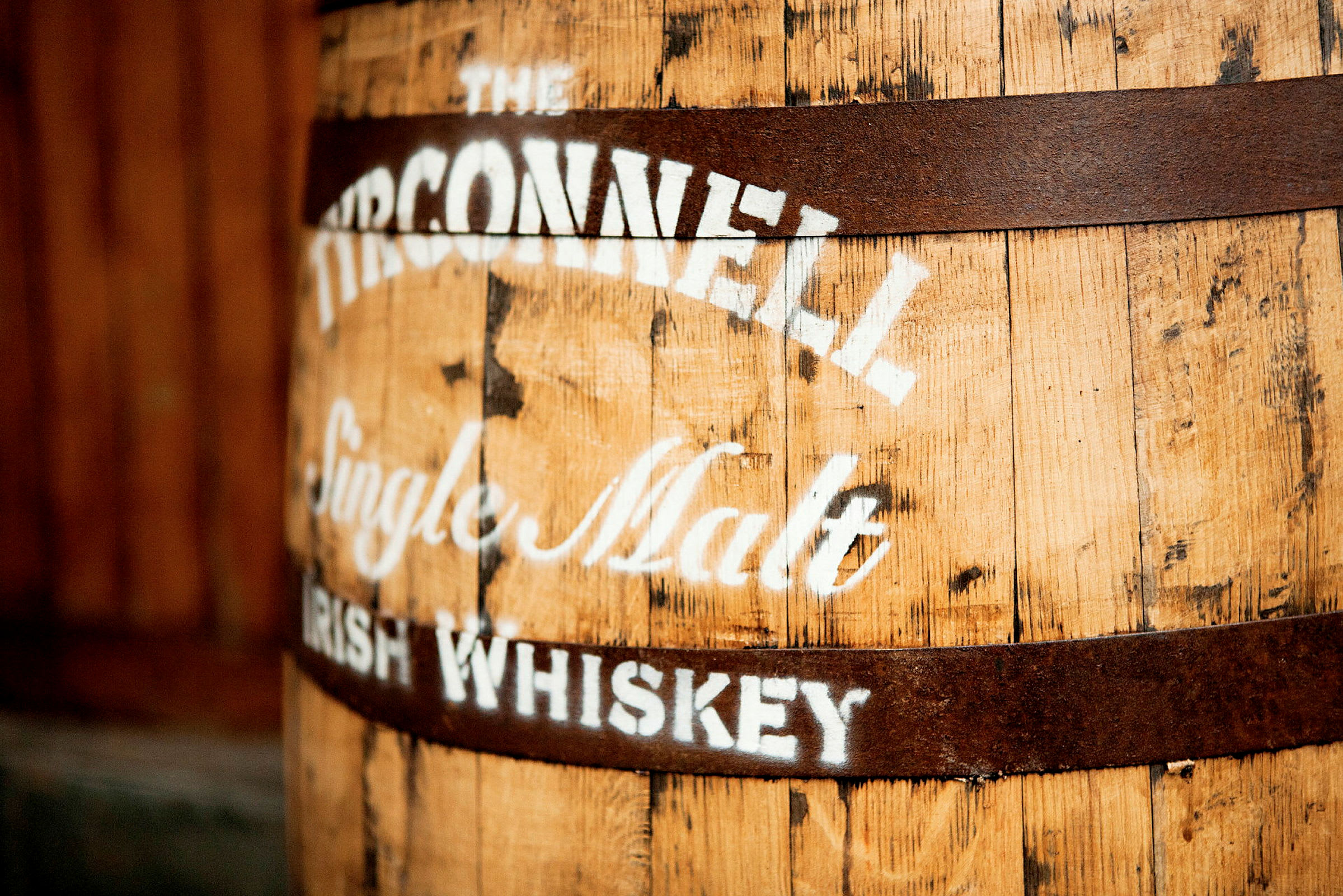 En gammel trætønde med en tekst, der angiver "The Tyrconnell Single Malt Irish Whiskey" malet på overfladen. (AI-genereret tekst)