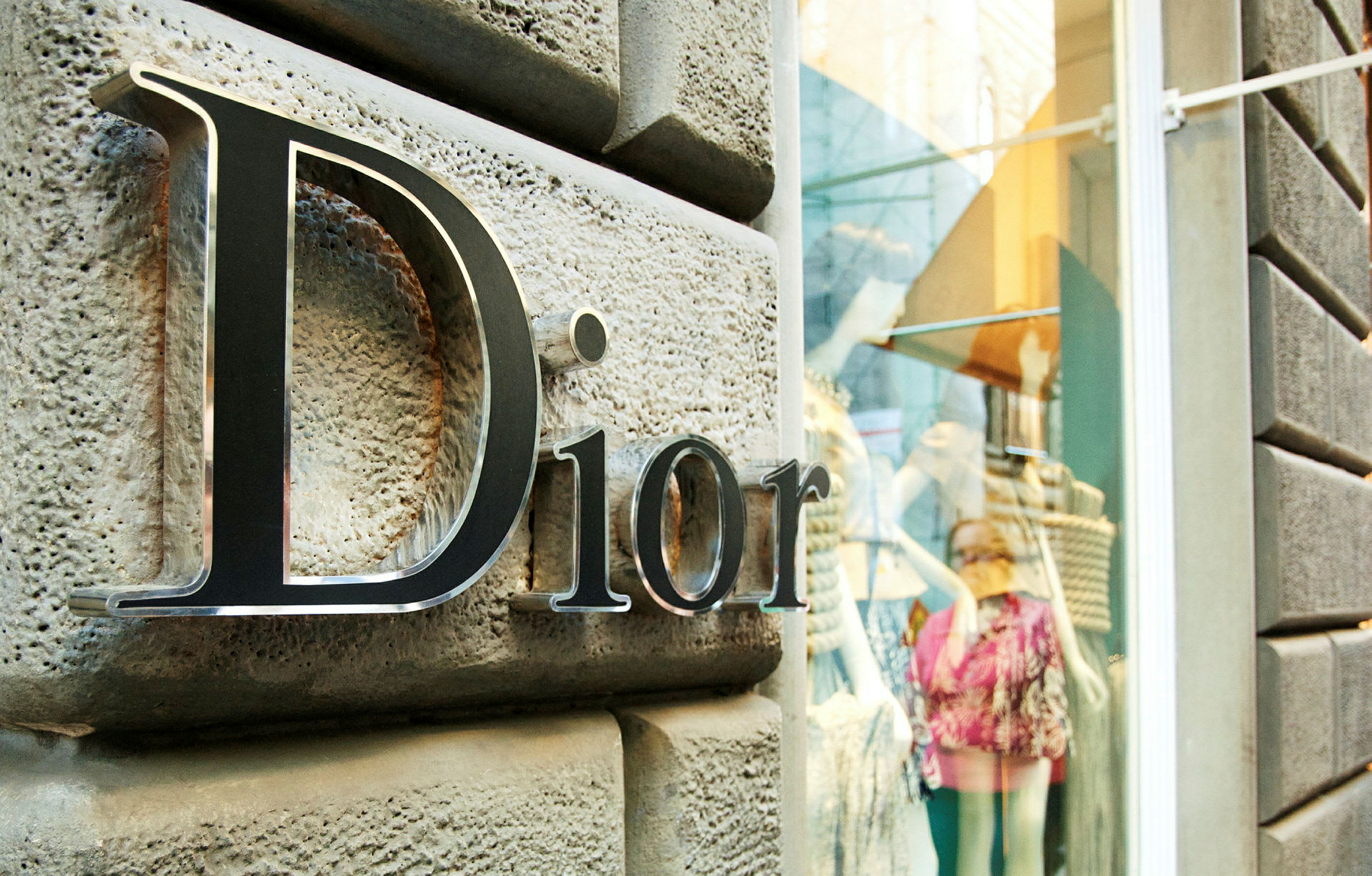 Dior-skilt uden for en butik med udstillingsvindue. (AI-genereret tekst)