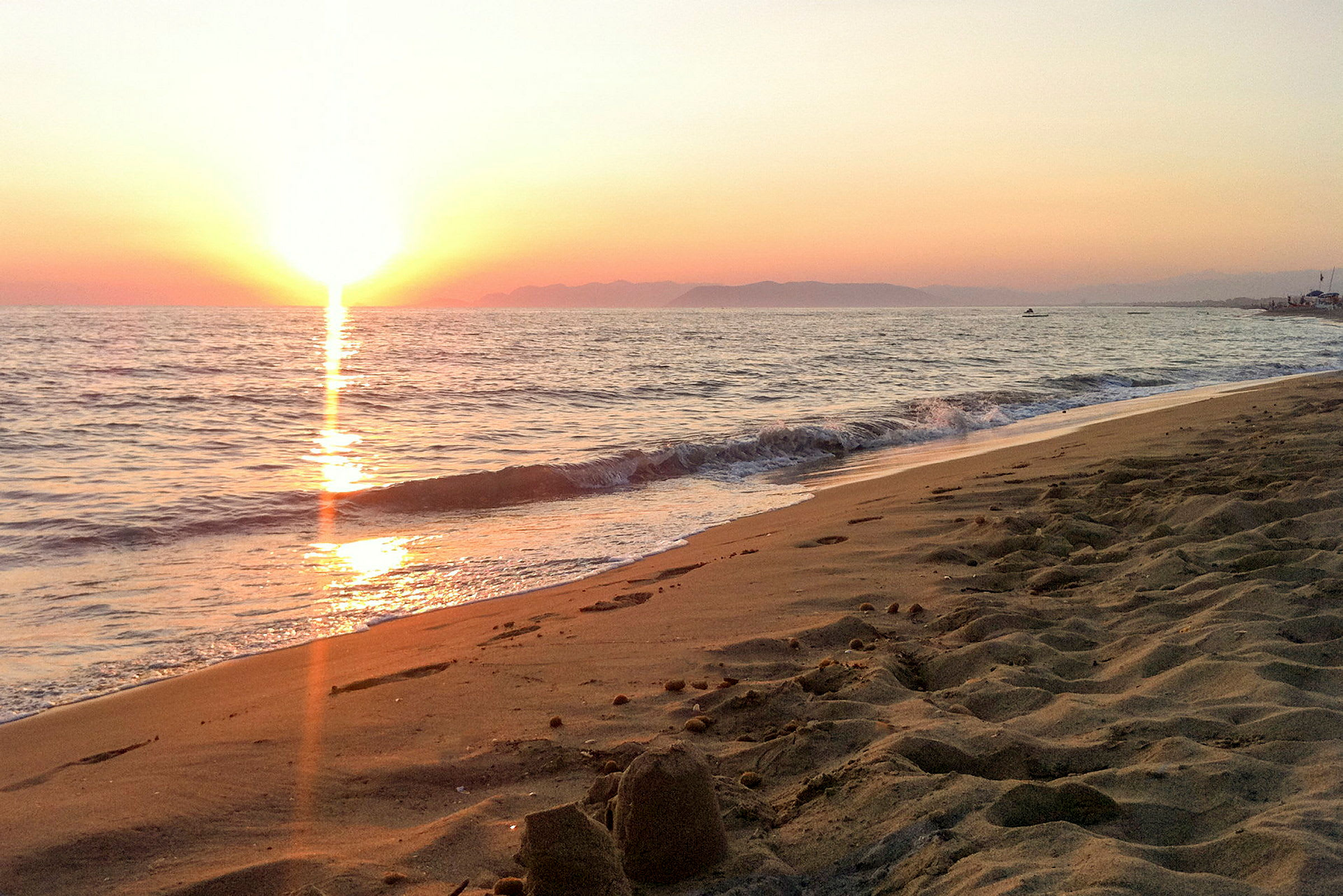 Solnedgang over havet ved en sandstrand. (AI-genereret tekst)