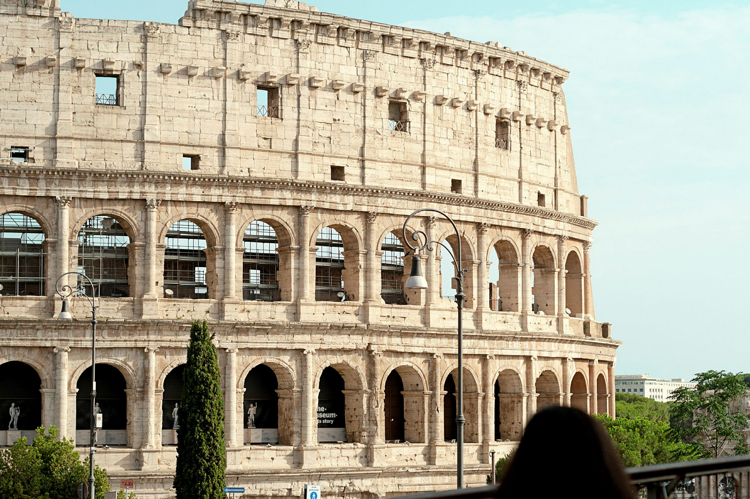 Billede af Colosseum i Rom, Italien, med en kvinde i forgrunden. (AI-genereret tekst)