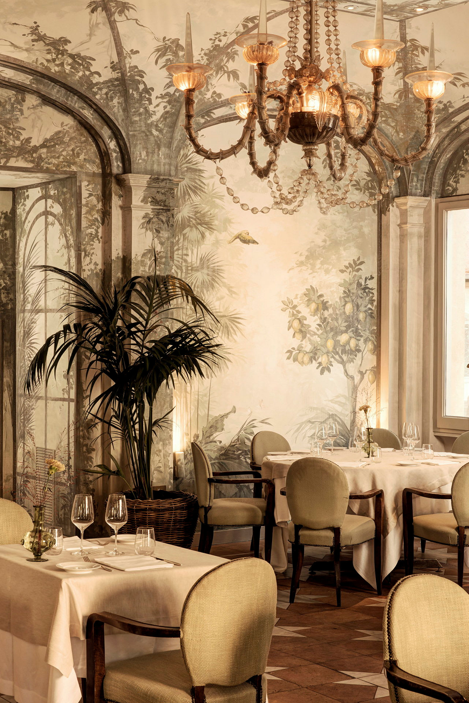 Restaurantinteriør med dækkede borde, elegante stole og en dekorativ lysekrone. (AI-genereret tekst)
