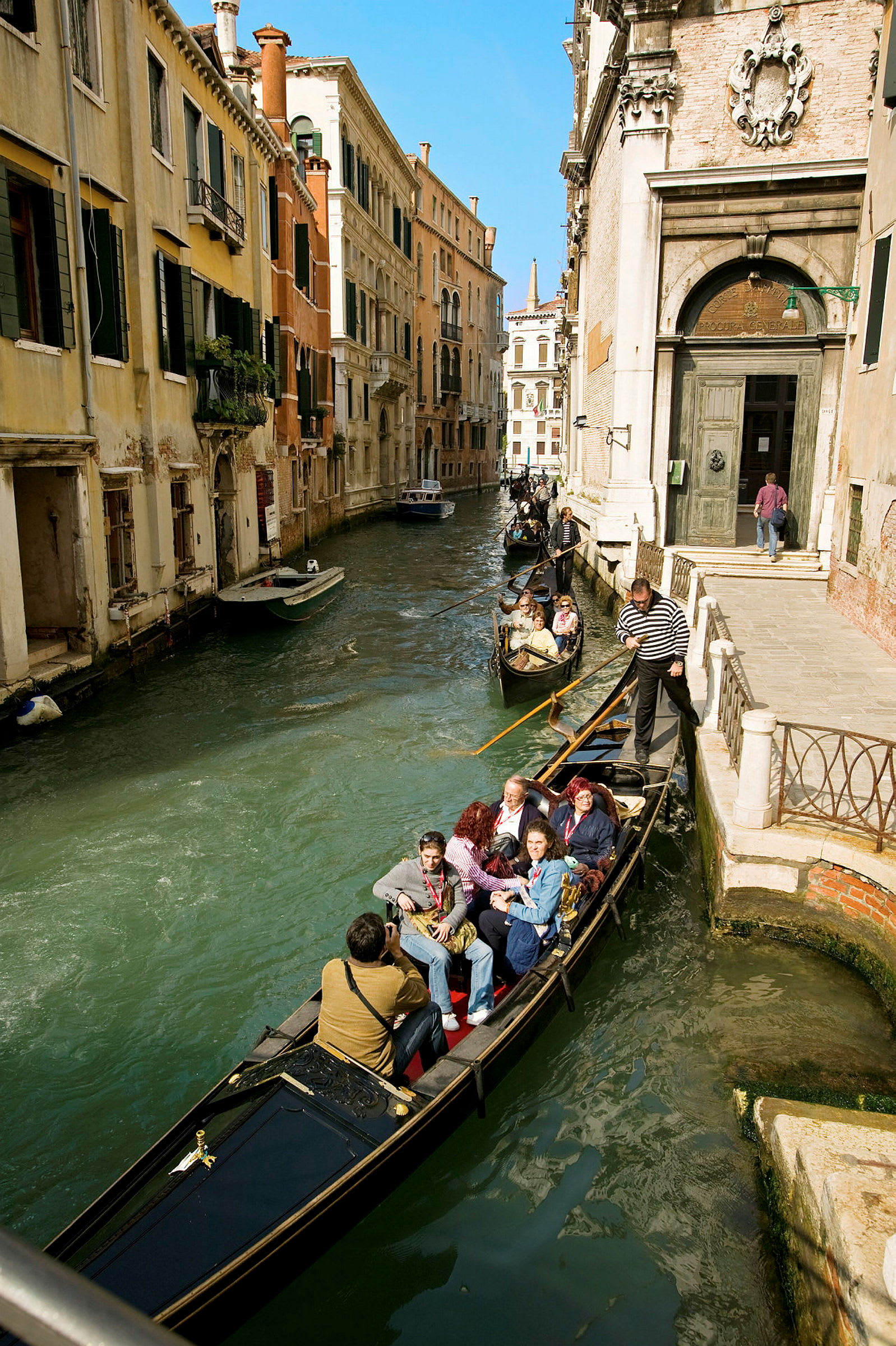 En gondol med passagerer sejler langs en kanal i Venedig. (AI-genereret tekst)