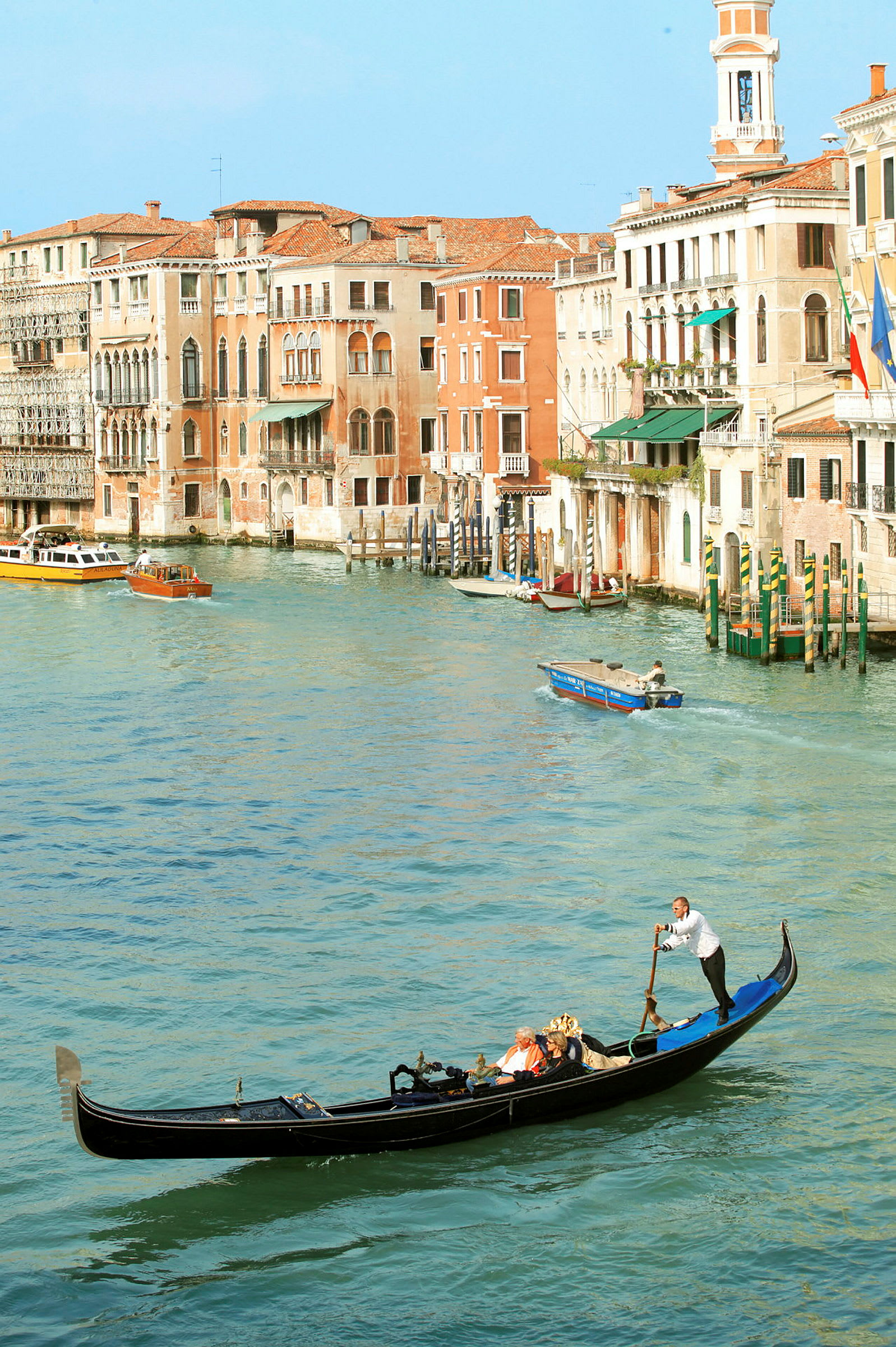 En gondol på en kanal i Venedig med historiske bygninger i baggrunden. (AI-genereret tekst)