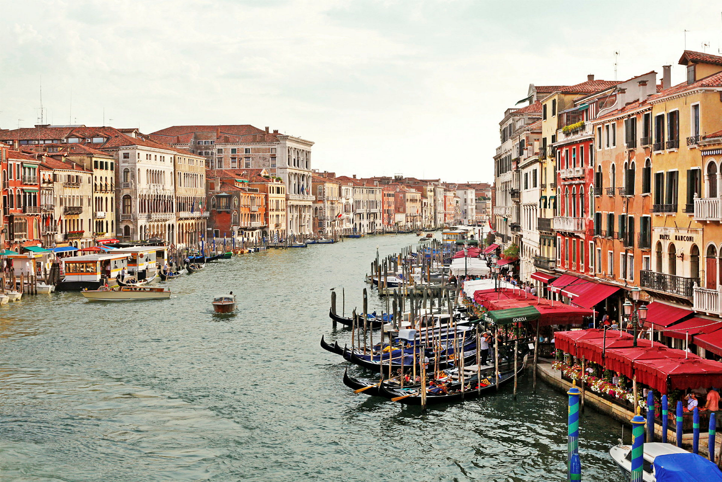En kanal med gondoler og farverige bygninger på begge sider i Venedig. (AI-genereret tekst)
