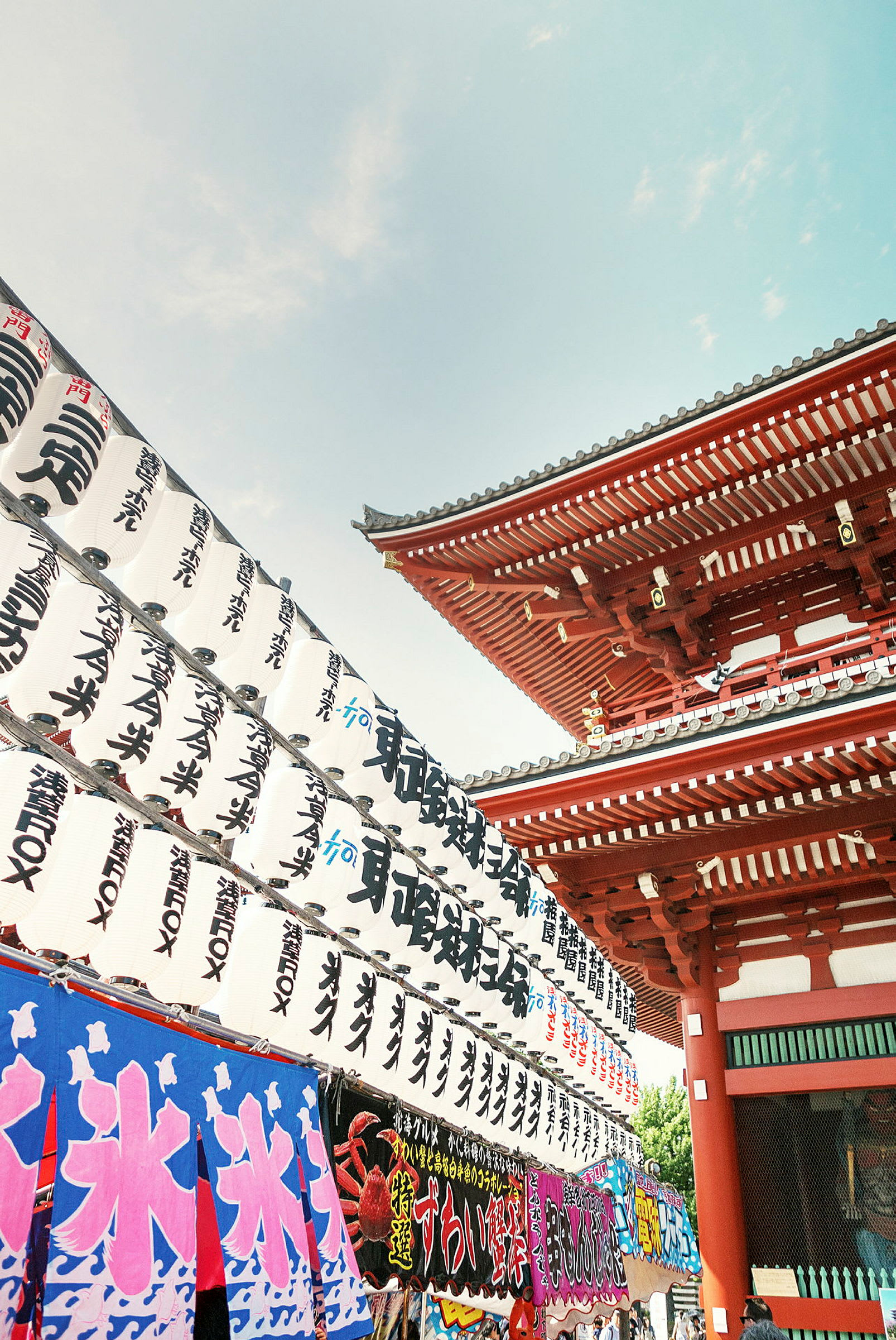 Japansk tempel med røde bygninger og dekorationer samt traditionelle hvide lanterner med japanske tegn. (AI-genereret tekst)