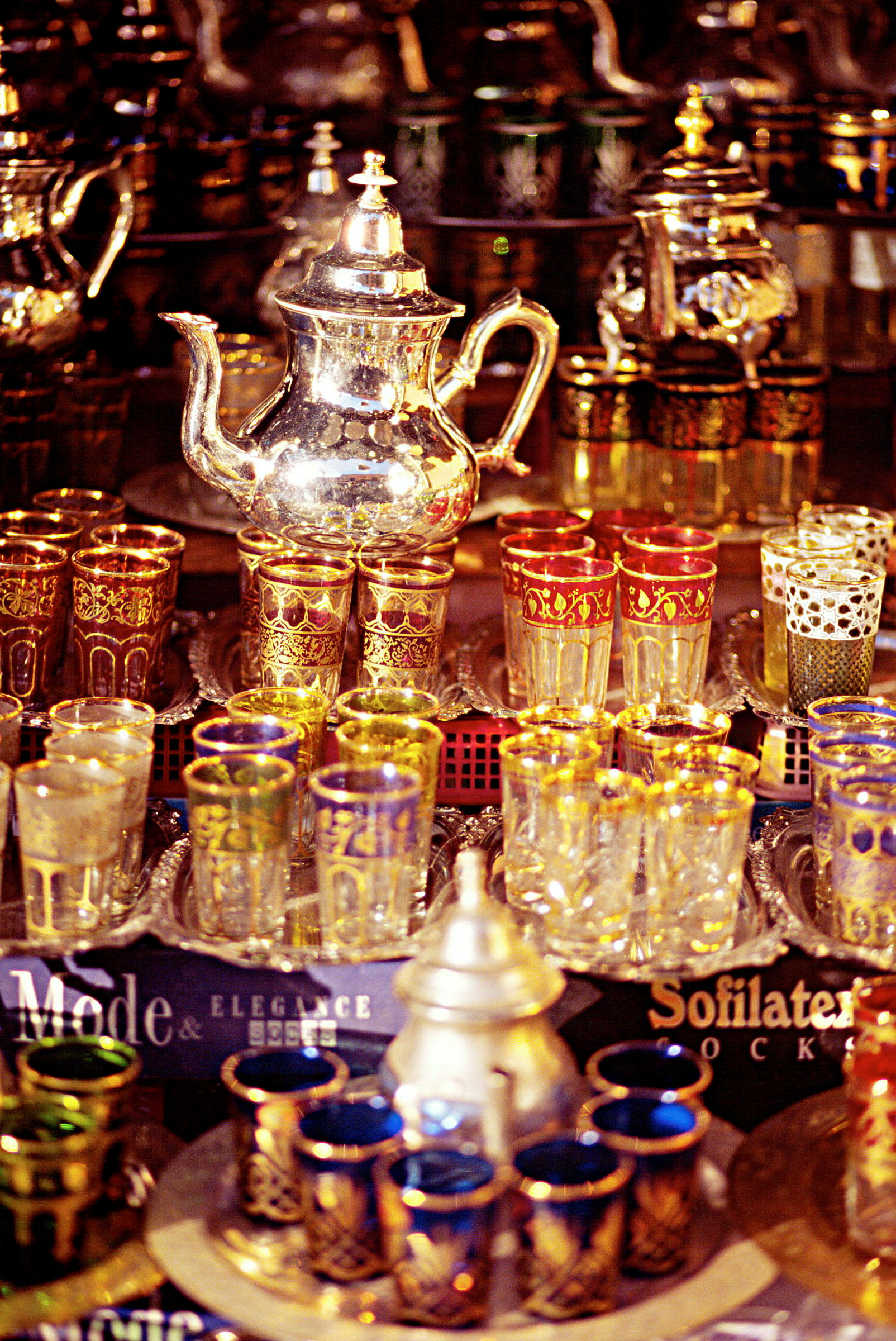 En samling af dekorative teakander og farverige glas med detaljeret ornamentering. (AI-genereret tekst)