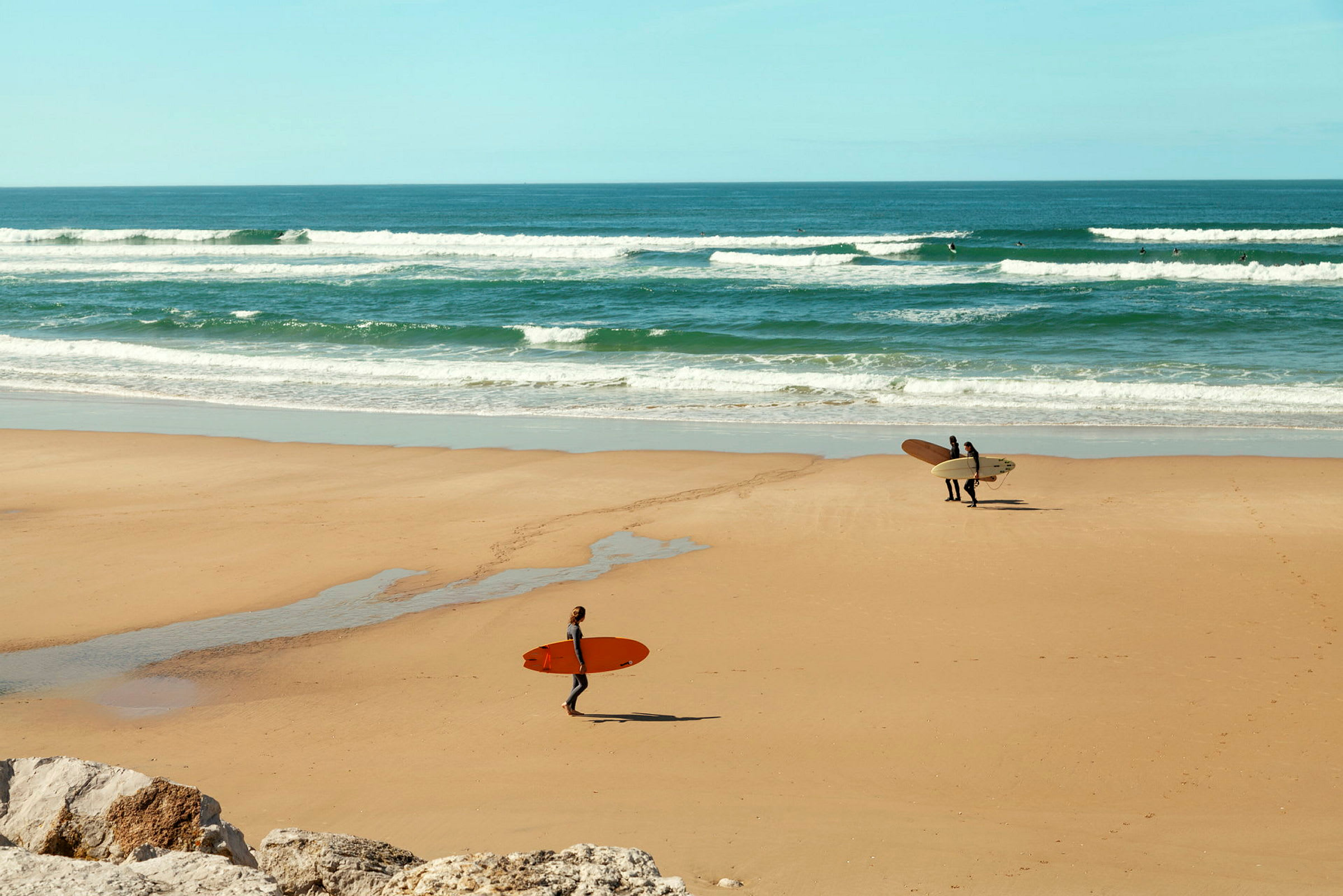 Surfere på en sandstrand med bølger i baggrunden. (AI-genereret tekst)