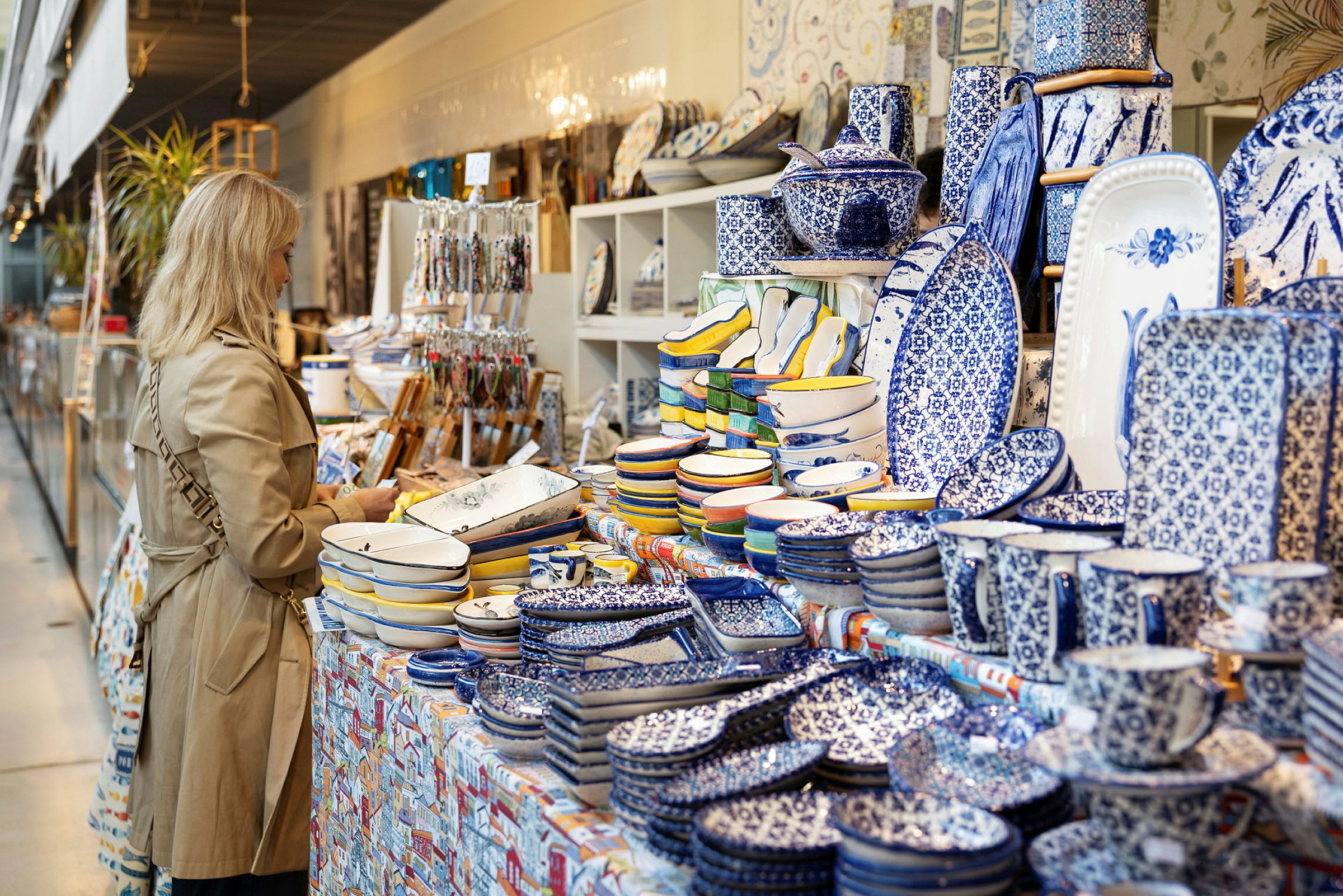 En butik med et bord fyldt med blåt og hvidt porcelæn og dekorerede keramikprodukter. (AI-genereret tekst)