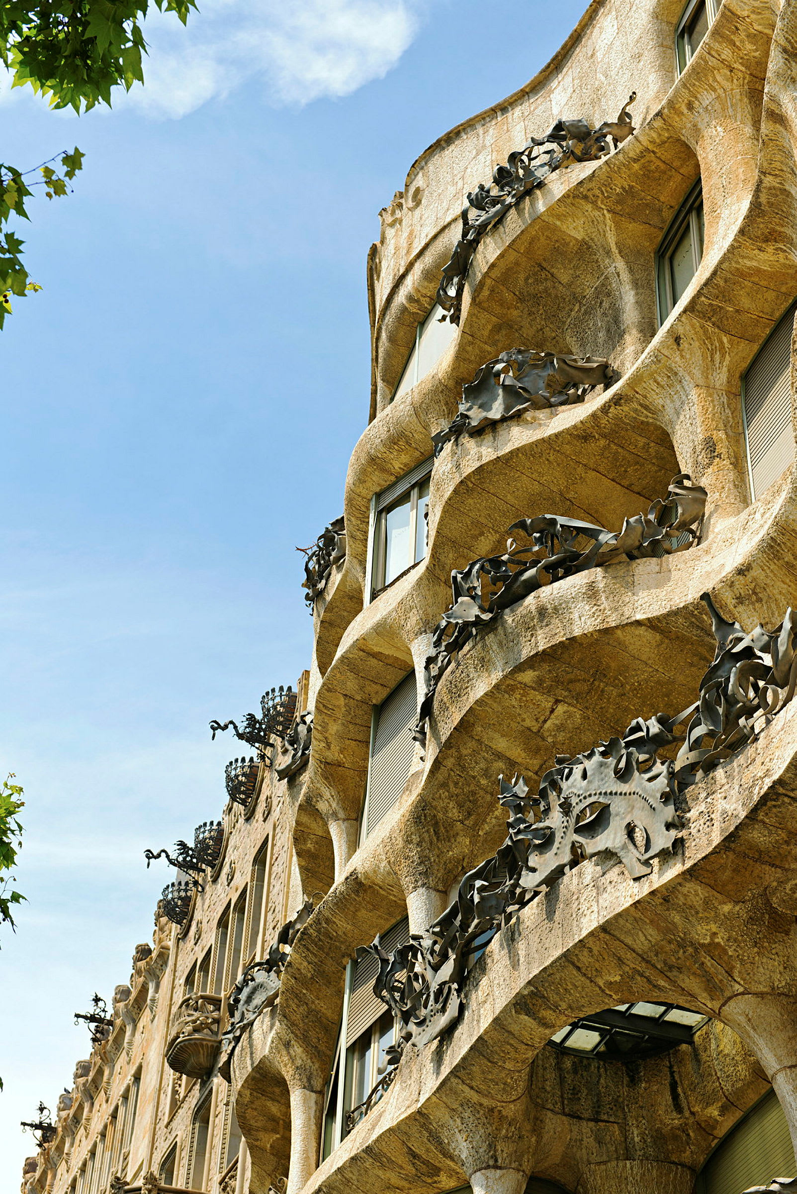 Nærbillede af den bølgende facade på Casa Milà, kendt som La Pedrera, i Barcelona. (AI-genereret tekst)