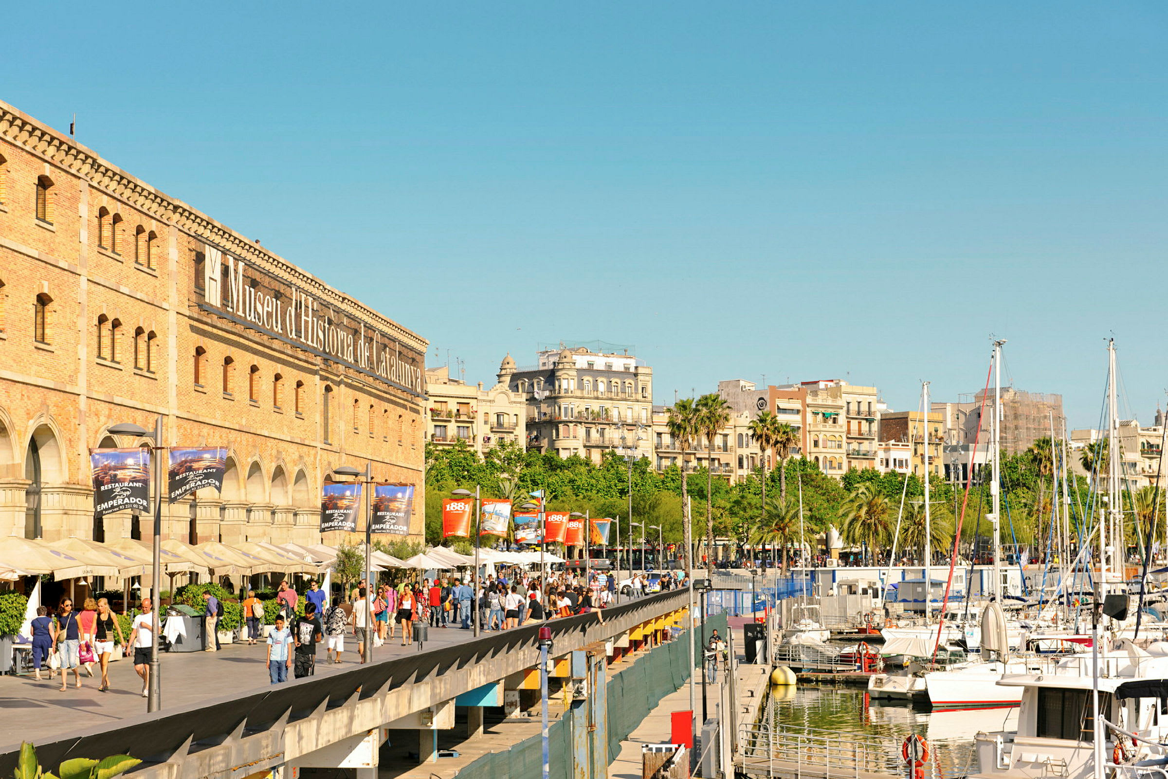 Promenade ved Museu d'Història de Catalunya og både i en havn. (AI-genereret tekst)